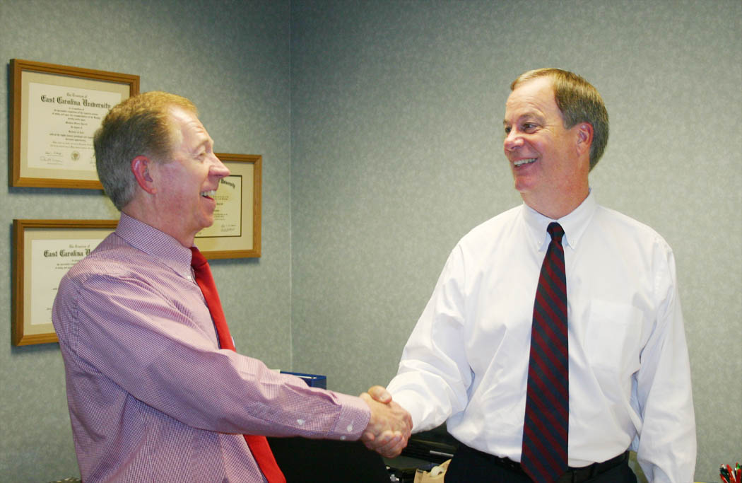 Click to enlarge,  Dr. Matthew Garrett (left), just-retired Central Carolina Community College president, welcomes the new president, Dr. Bud Marchant III, who assumed his position as of Aug. 15. Garrett's official retirement date is Sept. 1, but he has stepped down from the presidency to be available to assist Marchant during the transition period for the new president and the college. Marchant is the college's fifth president in its 47-year history.  