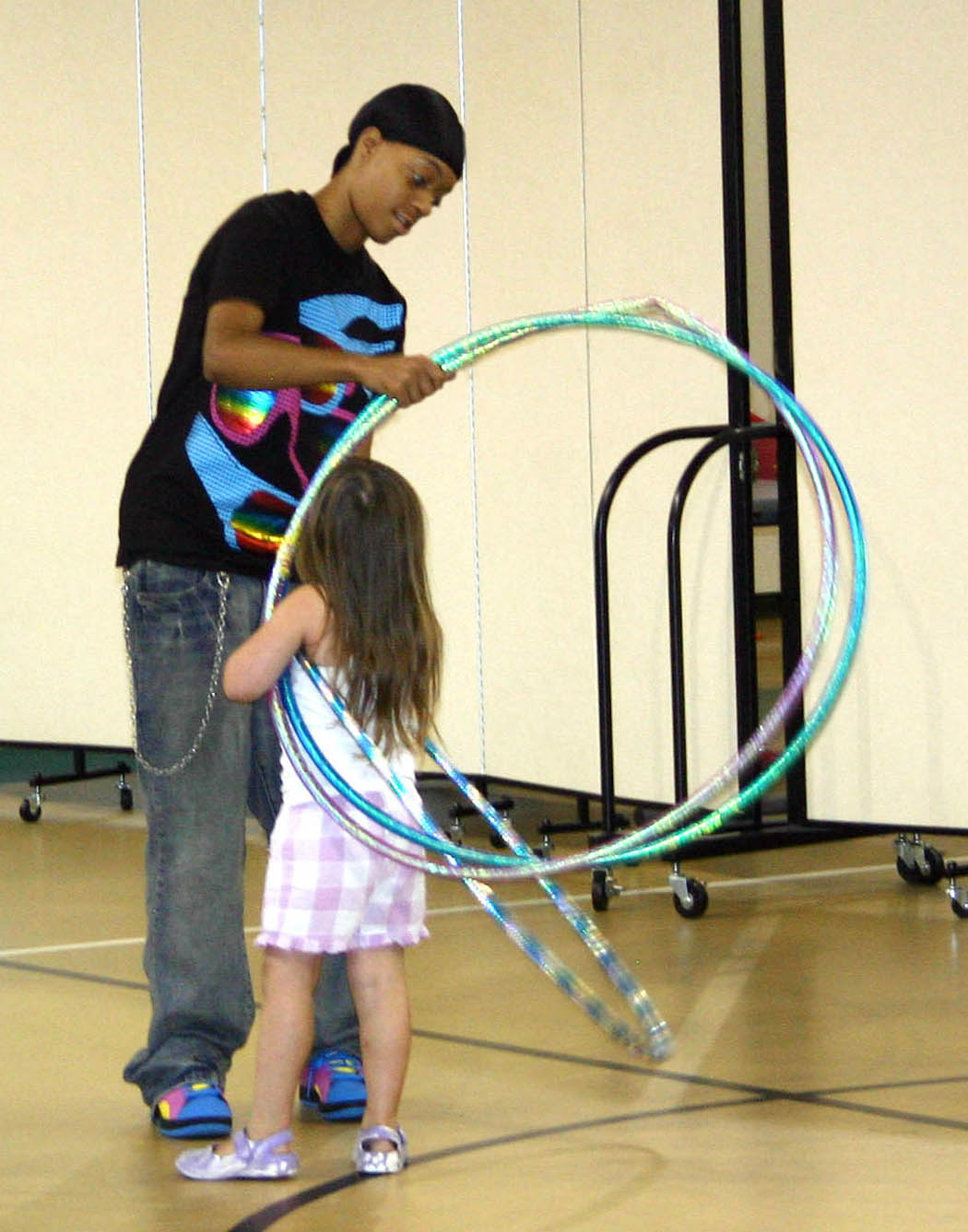Click to enlarge,  Faye McLean (left), of Sanford, assists Angelica Leake in playing with hoops during the Stevens Center&#8217;s Party, Paint and Playtime summer camp, held during June and July. McLean is enrolled in Central Carolina Community College&#8217;s early childhood education program. Her &#8216;Child, Family, and Community&#8217; class collaborated with nursing students from UNC-Chapel Hill to staff and plan activities for the Center&#8217;s summer camp for 2-to-4-year-olds and the Kids Can Connect camp for 5-to-8-year-olds. Both camps included children with and without disabilities. The nursing students gained experience working in the community and the CCCC students applied what they had learned in class about working with young children with and without disabilities, individually and in groups.  