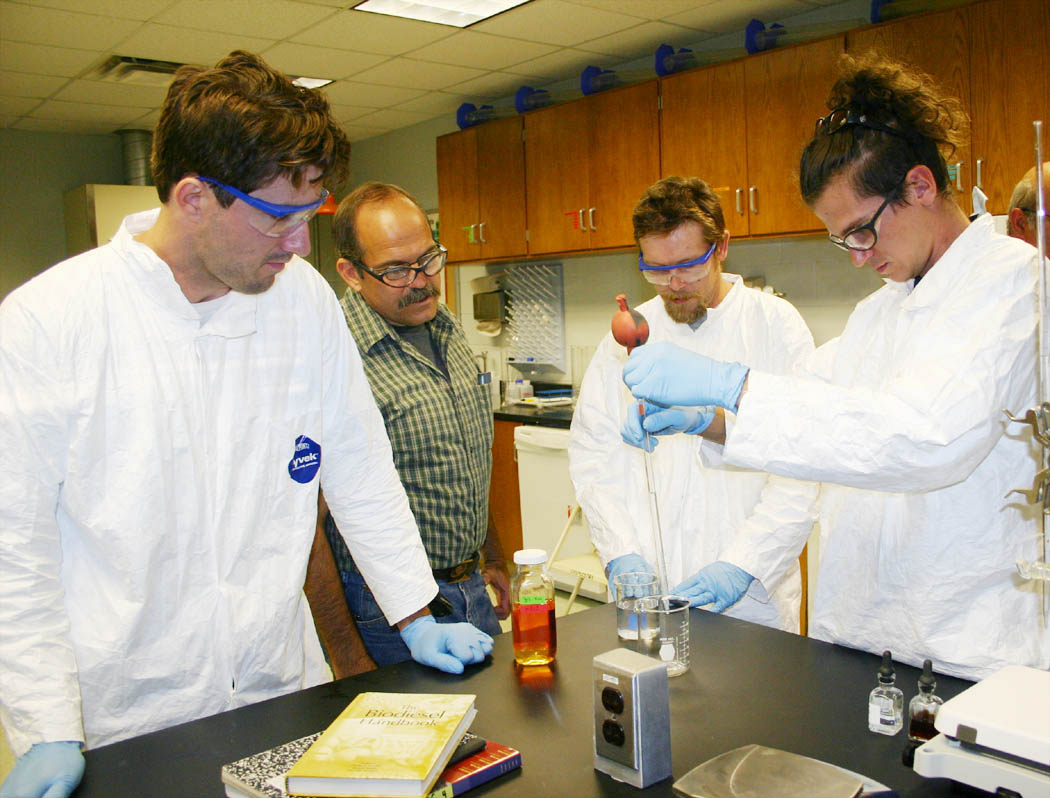 Click to enlarge,  Central Carolina Community College offers the only Alternative Energy Technologies: Biofuels associate degree program in the North Carolina Community College System. In the program's laboratory at the college's Chatham County Campus, in Pittsboro, instructor Bob Armantrout (second from left), of Moncure, explains to students (from left) Pierce Coleman Cassedy, of Chatham County, Will Mitchell, of Chapel Hill, and P.J. Bordelon, of Pittsboro, how to use a pipette pump in biofuel testing.  