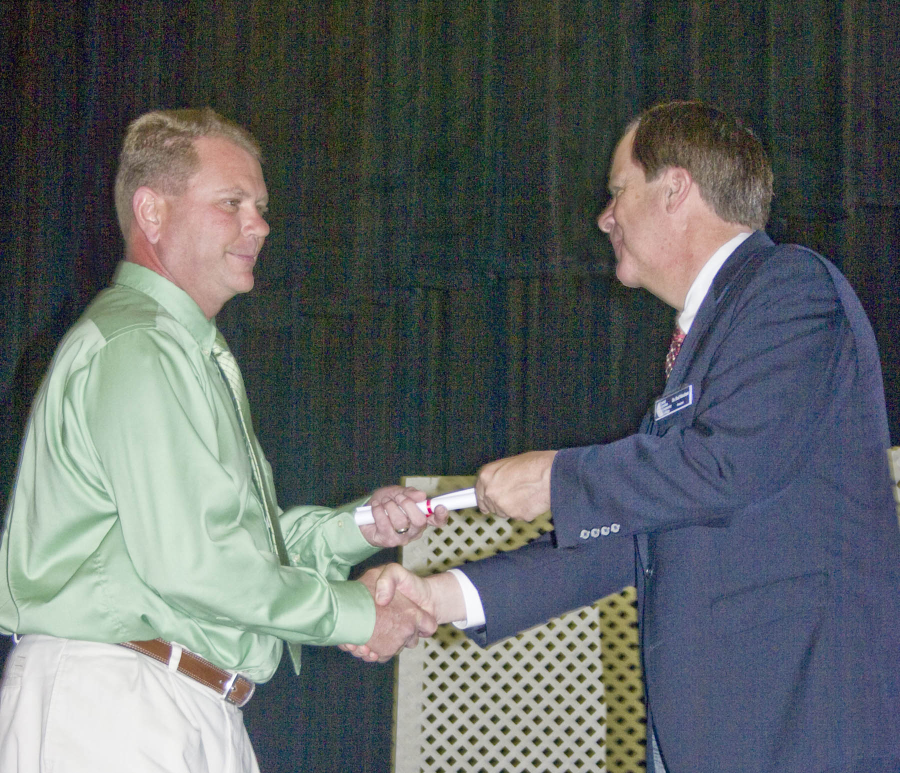 Click to enlarge,  Charles Hickman (left), of Lee County, receives congratulations and his EKG Monitor Technician Certificate from Central Carolina Community College President Bud Marchant during the college&#8217;s Lee County Continuing Education Department&#8217;s Medical Programs Graduation May 27 at the Dennis A. Wicker Civic Center. 