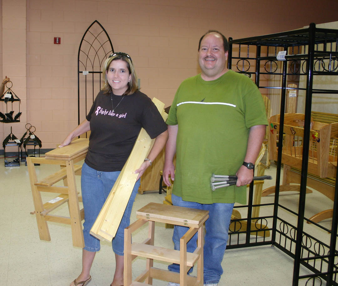 Click to enlarge,  Jennifer Byrd (left) and Donald Holder, both of Mamers, haul away some stools, part of their highest-bid winnings at the Central Carolina Community College Foundation&#8217;s Furniture Auction June 6. The auction, at the college&#8217;s Harnett County Campus in Lillington, attracted more than 100 people. A variety of wood and metal furnishings were auctioned for a total of more than $19,000. Student inmates of the college&#8217;s carpentry and welding programs in the Harnett Correctional Institution made all the items. Proceeds from the annual auction go into an endowment that provides scholarships for Central Carolina students from Harnett County. 