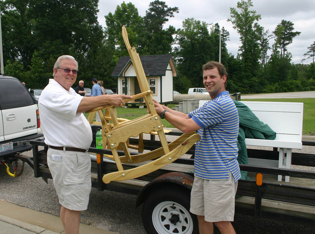 Click to enlarge,  Joe Giles (left) and his son, Michael Giles, both of Dunn, load a porch rocker onto their trailer following the Central Carolina Community College Foundation&#8217;s Furniture Auction June 6. The auction, at the college&#8217;s Harnett County Campus in Lillington, attracted more than 100 people. A variety of wood and metal furnishings were auctioned for a total of more than $19,000. Student inmates of the college&#8217;s carpentry and welding programs in the Harnett Correctional Institution made all the items. Proceeds from the annual auction go into an endowment that provides scholarships for Central Carolina students from Harnett County. 