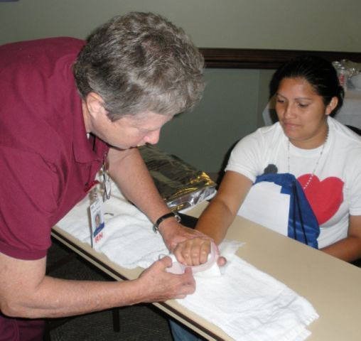 Click to enlarge,  Chris Burns (left), a Central Carolina Hospital Emergency Room nurse, shows splinting techniques to Mirian Viera, a student in Central Carolina Community College&#8217;s Basic Skills program. 