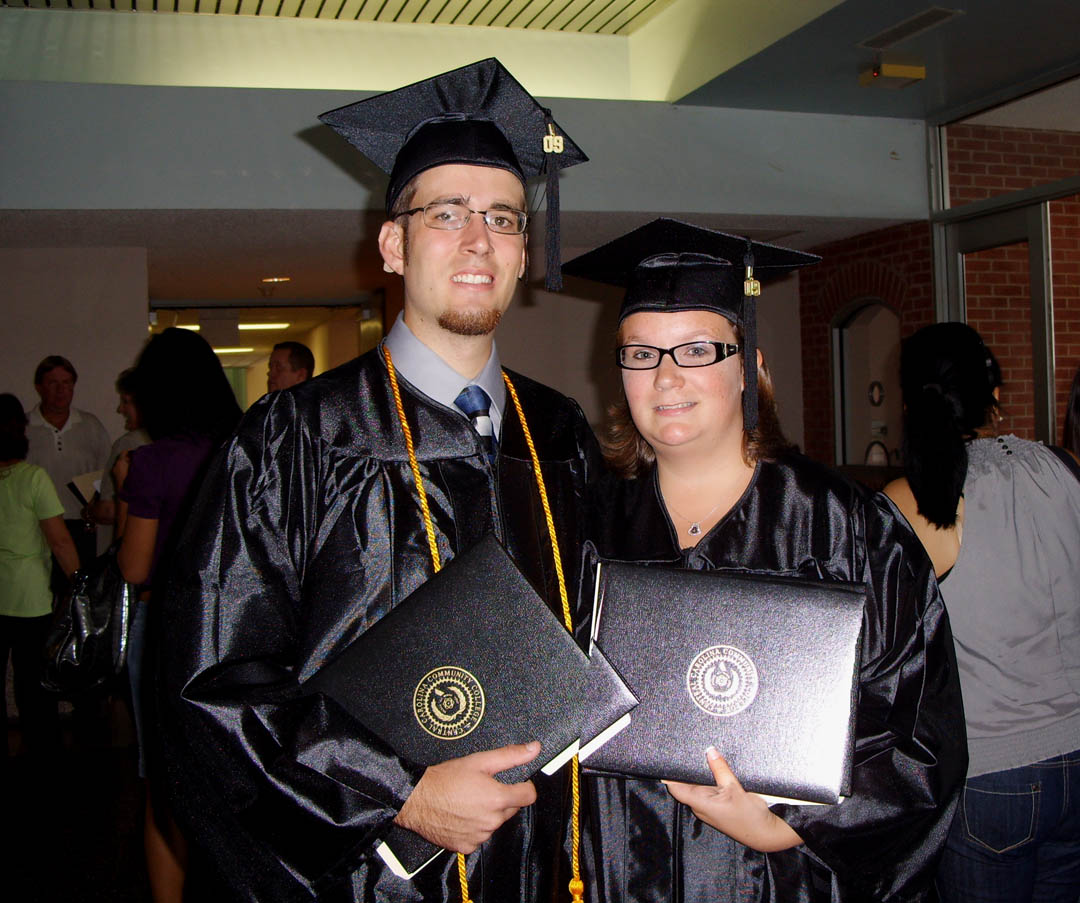 Click to enlarge,  Friends Michael Parker (left), of Sanford, and Sara Bristol, of Pittsboro, hold their degrees proudly following their graduation from Central Carolina Community College Aug. 6 at the Dennis A. Wicker Civic Center. Bristol received her A.A.S. in Veterinary Medical Technology. Parker received his A.A.S. in Mechanical Engineering Technology. Parker lost his hearing as a young child due to illness but received a cochlear implant at age 3 to restore partial hearing. Carol Habeeb (not pictured), his speech teacher since kindergarten, was on hand to help celebrate his graduation from CCCC. 