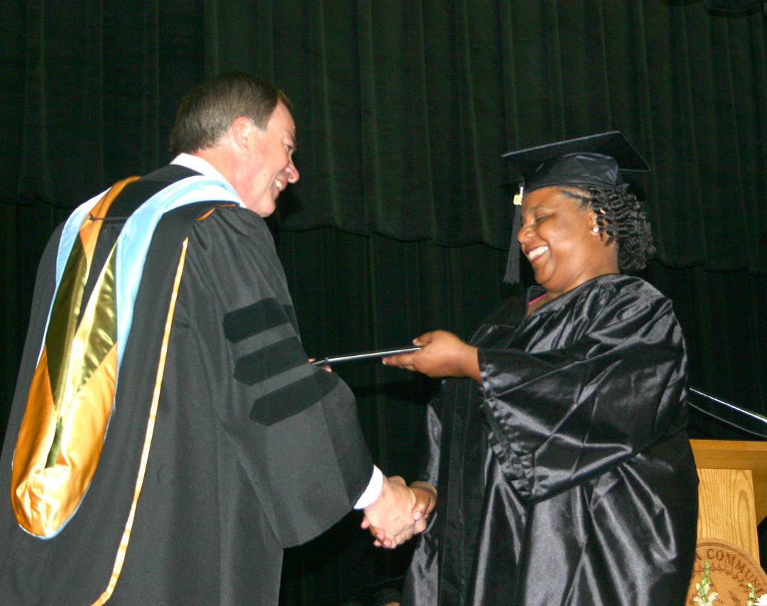 Click to enlarge,  Central Carolina Community College President Bud Marchant (left) presents a very happy Judy Snipes, of Chatham County, with her Medical Assisting Diploma during the college&#8217;s Summer Graduation Commencement Exercises Aug. 6 at the Dennis A. Wicker Civic Center.&amp;nbsp; 