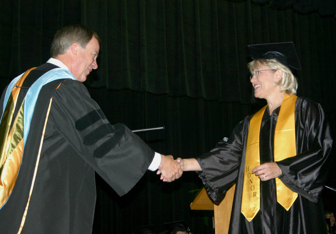 Click to enlarge,  Central Carolina Community College President Bud Marchant (left) awards Bonnie Pope, of Harnett County, her Medical Assisting Diploma during the college&#8217;s Summer Graduation Commencement Exercises Aug. 6 at the Dennis A. Wicker Civic Center. Pope was one of three student speakers for the event and was also honored for having one of the highest grade point averages in the graduating class.&amp;nbsp; 