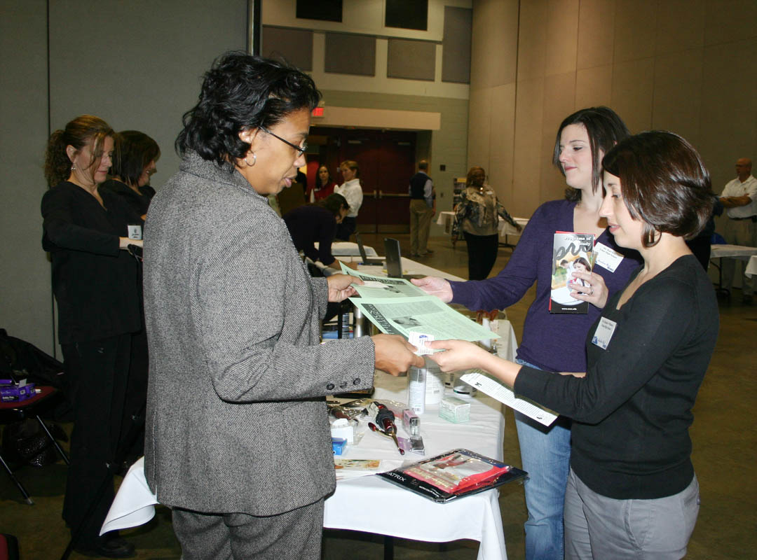Click to enlarge,  Janice Fenner (left), chair of the Cosmetology Department at Central Carolina Community College, shares information about the programs in the department with Triton High School counselors Heather Williams (right, front) and Kari Kite (right, back) during the college&#8217;s 34th annual Information and Planning Conference Nov. 13 at the Dennis A. Wicker Civic Center. Educators from schools in seven counties gathered to learn about educational opportunities for their students and graduates at the college. The 2009 event had workshops on the University Transfer/Associate in Science, Networking and Telecommunications Technology, Green Central Sustainable, and Business Technologies programs. Other programs, including Cosmetology, had display and informational areas. 
