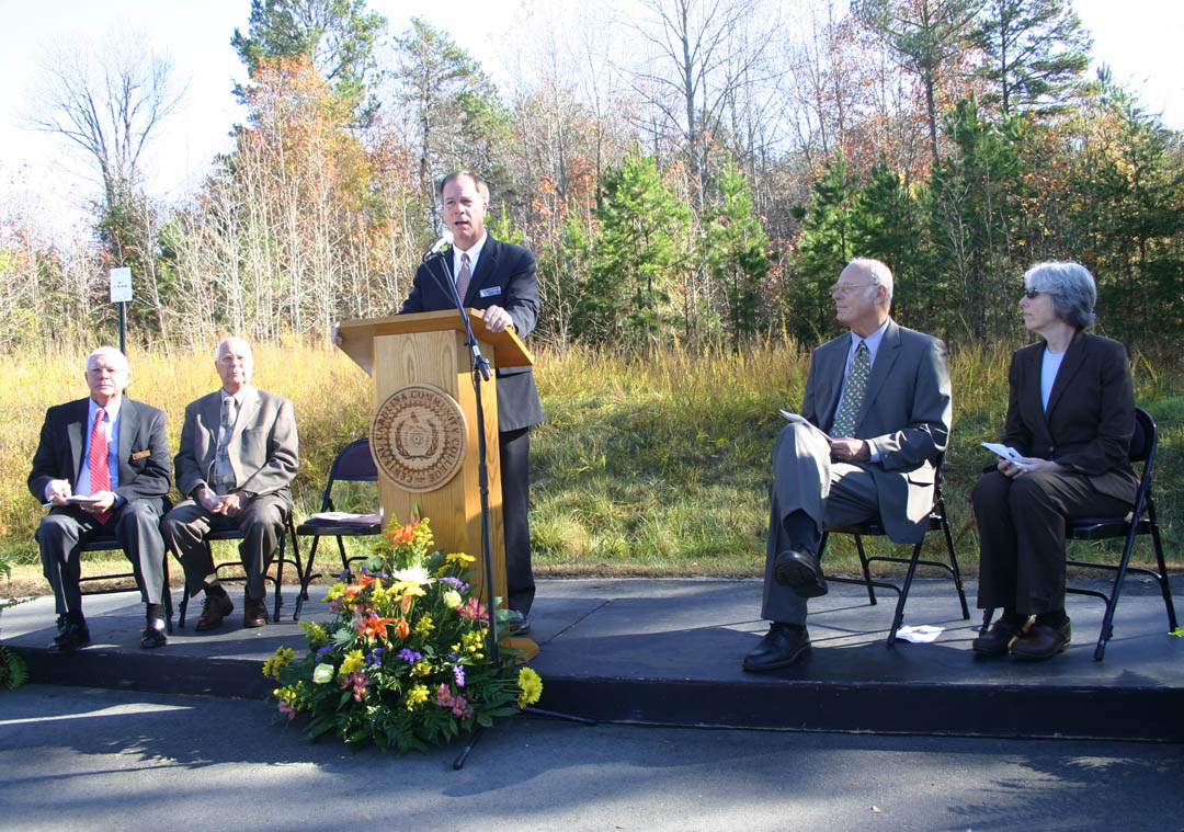 Click to enlarge,  Central Carolina Community College President Bud Marchant (at podium) addresses those gathered for the groundbreaking ceremony for the college&#8217;s new Siler City Center. The Center, located in the Central Carolina Business Campus, will enable the college to expand educational opportunities and workforce training for the residents of western Chatham County. Also speaking at the groundbreaking were (from left) Bobby Powell, chairman of the Central Carolina Community College Board of Trustees; Charles Turner, mayor of Siler City; George Lucier, chairman of the Chatham County Board of Commissioners and CCCC trustee; and Dianne Reid, president of the Chatham County Economic Development Corporation. 