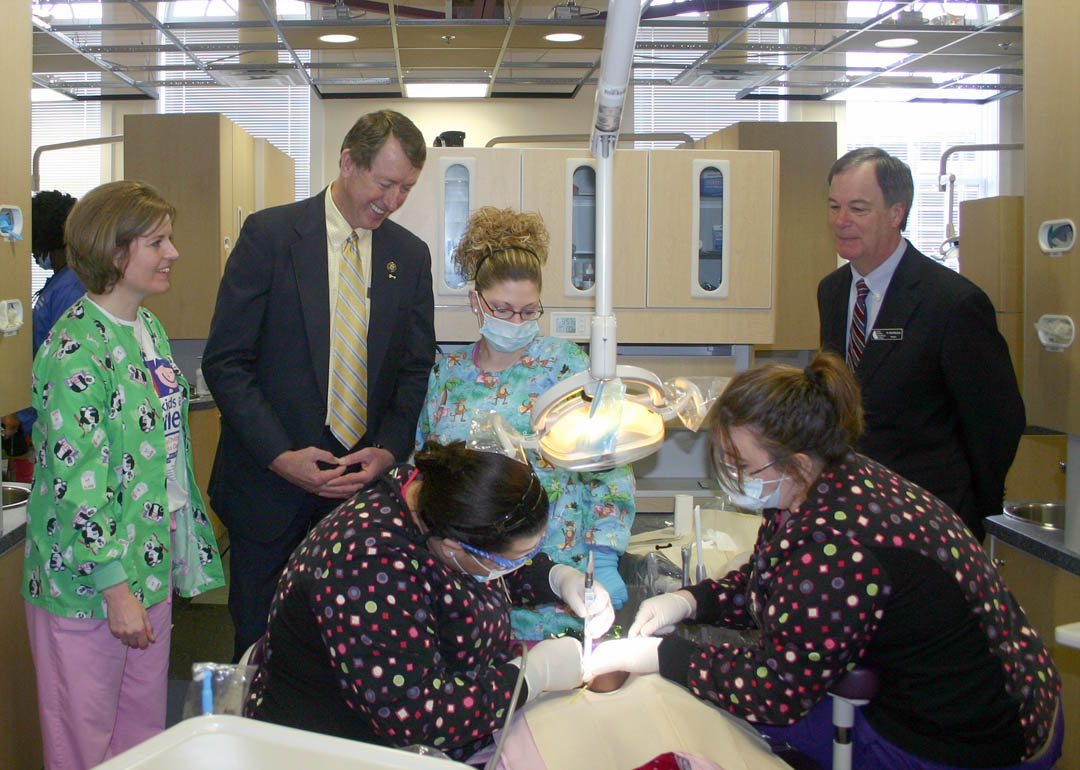 Click to enlarge,  Congressman Bob Etheridge (standing, second from left), of N.C.&#8217;s Second District, visited the Give Kids A Smile event Feb. 12 at Central Carolina Community College&#8217;s Dental Programs at the W.B. Wicker Center, in Sanford. The event was a collaborative effort of the Dental Programs, Lee County Dental Society, and the N.C. Department of Health and Human Services. Pictured are (back, from left) Wendy Seymore, Public Health dental hygienist for Chatham and Lee counties, who organized the event; Etheridge; volunteer Crystal Stratton, dental assistant at Sanford Pediatric Dentistry; and CCCC President Bud Marchant. CCCC dental assisting students Alishia Cheek (front, left), of Chatham County, and Dana Daniels, of Johnston County, apply sealant to a Greenwood Elementary School student&#8217;s teeth. Volunteers for the event included dentists Dr. Stephen Coker, of Cary, and Dr. Susan Madden and Dr. Kelly Faulkner, of Sanford; orthodontists Dr. Brian Smith and Dr. Lynn Smith, of Sanford; and members of their staffs. Give Kids A Smile is part of the American Dental Association&#8217;s Children&#8217;s Dental Health Month in February. While at W.B. Wicker, Etheridge also learned about the college&#8217;s Lifelong Learning Center for adult education and WIA-Workforce Development. For more information on Central Carolina&#8217;s dental programs, which are fully accredited by the American Dental Association&#8217;s Commission on Dental Accreditation, go online to  www.cccc.edu/curriculum/majors/dental or call the college&#8217;s Dental Programs Clinic at (919) 775-2122. For more information on &#8220;Give Kids A Smile,&#8221; visit the American Dental Association web site, www.ada.org . For more on adult education, go to  www.cccc.edu/ecd . 