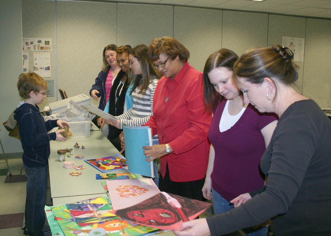 Click to enlarge,  Ten-year-old Ian Higgins (left) shares examples of his artwork with students in Central Carolina Community College&#8217;s Early Childhood Education Creative Activities class Feb. 9 at the college&#8217;s Lee County Campus. Higgins, a fourth grader at Mary Scroggs Elementary School, in Chapel Hill, is the grandson of class instructor David Leperi, of Pittsboro. The CCCC students are learning about the use of creative activities in educating young children. They were interested in getting a child&#8217;s perspective on creative activities and ideas on what can be done from his work in clay modeling, watercolor, collage, and pastels. Pictured (right, from front) are ECE students Kimberly Liles, of Sanford; Janelle Parker, of Broadway; Brenda Harrington, Nicole Turner and Patricia Sellers, all of Sanford; and Heather Fawcett, of Cameron. For more information about CCCC&#8217;s Early Childhood Education programs, visit &amp;nbsp; www.cccc.edu/curriculum/majors/earlychildhood . 