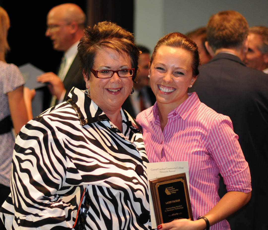 Click to enlarge,  Central Carolina Community College student Lacey Fachan (right), of Moore County, shares a hug with Lisa Duncan, lead Paralegal instructor, at the college&#8217;s Academic Excellence Awards program May 5 at the Dennis A. Wicker Civic Center. Fachan received the Outstanding Student in Paralegal Technology Award. She received her Associate in Applied Science in Paralegal Technology at the college&#8217;s May 13 commencement. 