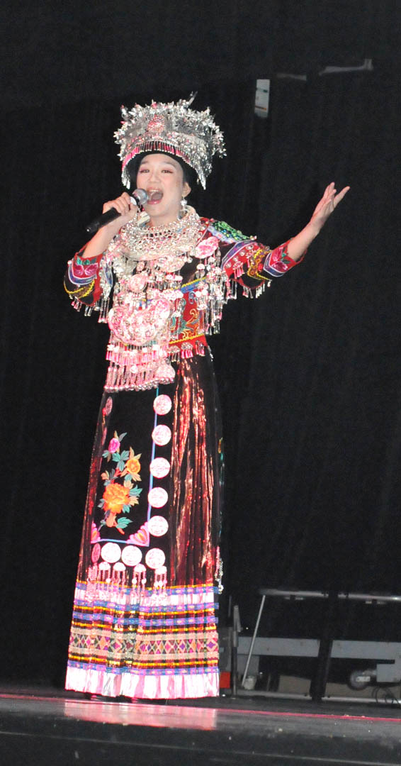 Click to enlarge,  Zhile Yue, a member of the Ethnic Arts Troupe at Jishou University&#8217;s College of Music and Dance, sings during the troupe&#8217;s show Sunday at the Dennis A. Wicker Civic Center. Yue, a professor at the university, wears the richly decorated traditional costume of the Miao ethnic group in Hunan Province, the People&#8217;s Republic of China, and sings one of the group&#8217;s drinking songs. The troupe performed, with dance, song, and instruments, 11 traditional songs, primarily from the Miao and Tujia ethnic groups in the province, where the university is located. Martial artists demonstrated kung fu as part of the program. Central Carolina Community College&#8217;s Confucius Classroom, in partnership with North Carolina State University&#8217;s Confucius Institute, hosted the free performance. For more information about CCCC&#8217;s Confucius Classroom, visit  www.cccc.edu/confucius  or call (919) 718-7386 or (919) 718-7376. 
