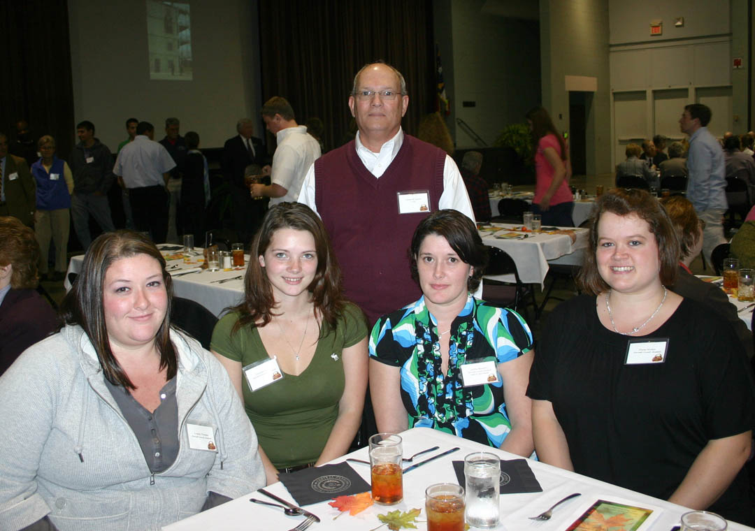 Click to enlarge,  Several hundred scholarship donors and recipients gathered Nov. 16 at the Dennis A. Wicker Civic Center, in Sanford, for the Central Carolina Community College Foundation Scholarship Luncheon. The luncheon provided an opportunity for the donors to become personally acquainted with those they are helping and enabled the recipients to thank them in person. Edward Taylor (standing), CCCC carpentry instructor at Harnett Correctional Institution, represented the donors of the Harnett Student Scholarship. Recipients of the scholarship were: (seated, from left) nursing student Crystal Thomas, of Mamers; university transfer student Lauren Busche, from Fuquay Varina; nursing student Jackie Beaston, of Coates, and nursing student Dana Wicker, of Broadway. For information on establishing scholarships or endowments, contact the CCCC Foundation at (919) 718-7231 or  dglover@cccc.edu . 
