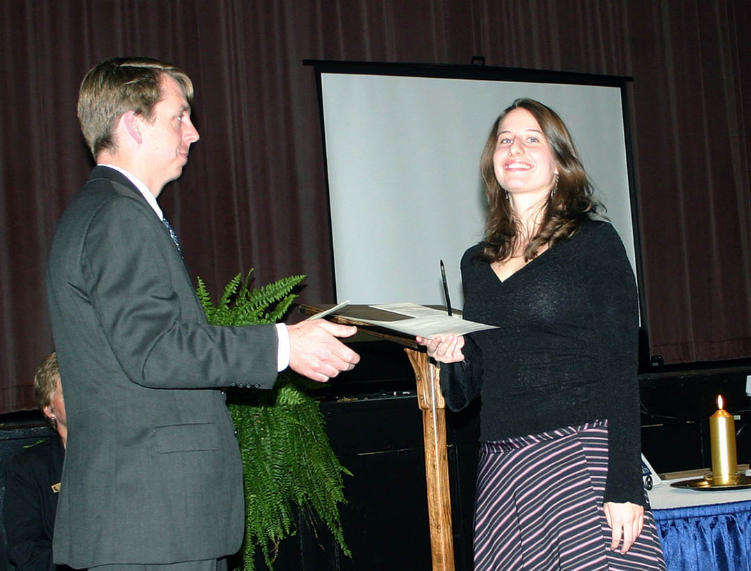 Click to enlarge,  Central Carolina Community College student Charlon Wright (right), of Cameron, receives her Phi Theta Kappa International Honor Society charter membership certificate from Mark Hall, the college chapter&#8217;s faculty advisor, during a Nov. 4 chartering and induction ceremony at the Dennis A. Wicker Civic Center. The college now has the Beta Sigma Phi Chapter of PTK, the largest honor society in American higher education. To be eligible, students must have a minimum of 12 credit hours and a grade point average of 3.5 or higher. The CCCC chapter requires a 3.7 GPA. Fifty-five CCCC students were inducted as charter members. 