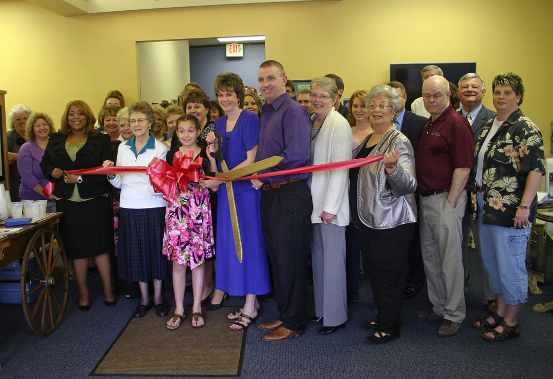 Click to enlarge,  Dr. Angela Bright Pearson (center), owner of Bright Audiology, cuts the ribbon for her new 3,000 square-foot office at 1620 S. Third St., Sanford, at an April 12 open house. Assisting her are her husband, Bruce Pearson (at her left), and their daughter, Hannah (at her right). Patients, local elected officials, family, friends, and representatives of the Sanford Area Chamber of Commerce and Central Carolina Community College&#8217;s Small Business Center gathered to celebrate the opening. Bright Pearson, a Doctor of Audiology, has been providing audiology services in Sanford since 1996. 