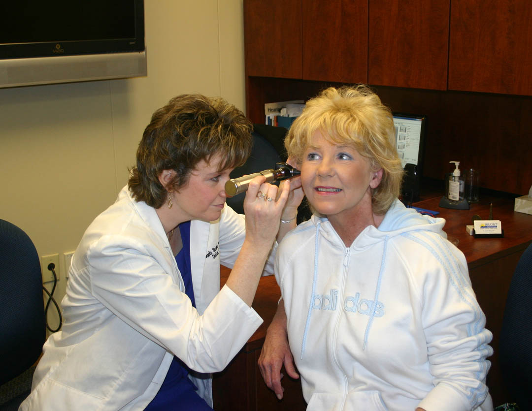 Click to enlarge,  Dr. Angela Bright Pearson checks the ear of patient Bernadette Unger, of Sanford, at Bright Audiology&#8217;s new location, 1620 S. Third St., Sanford. An open house and ribbon cutting for the new 3,000-square-foot facility was held April 12. Patients, local elected officials, family, friends, and representatives of the Sanford Area Chamber of Commerce and Central Carolina Community College&#8217;s Small Business Center gathered to celebrate the opening. Bright Pearson, a Doctor of Audiology, has been providing audiology services in Sanford since 1996. 