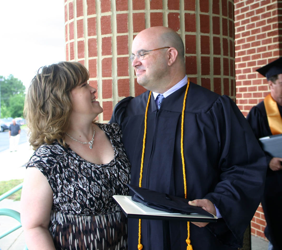 Click to enlarge,  Jill Olive (left), of Harnett County, has a big smile for her husband, David Olive following the May 17 Central Carolina Community College spring graduation, held at the Dennis A. Wicker Civic Center. David, who received his Associate in Applied Science in Laser and Photonics Technology, was among the more than 300 graduating students who attended either a morning or afternoon graduation exercise. Almost 1,000 associate degrees, diplomas and certificates were earned by the Class of 2011.&amp;nbsp; 