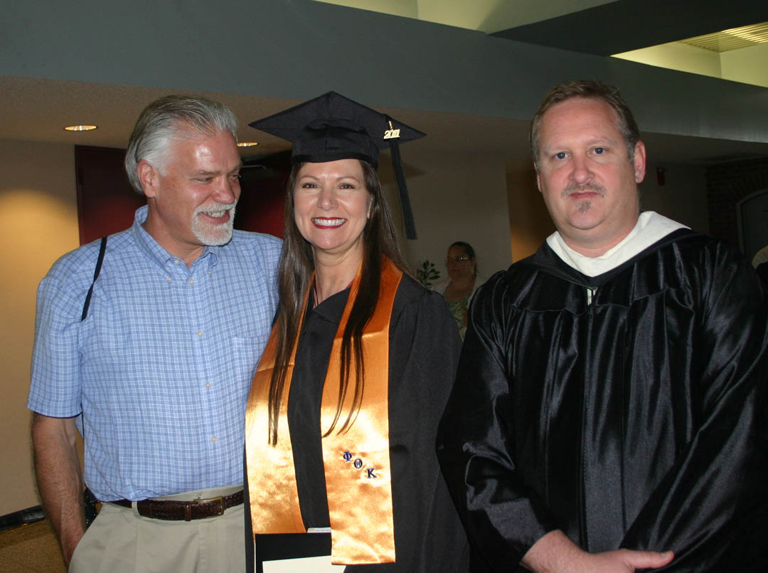 Click to enlarge,  Deborah Motter (center), of Lee County, has a big smile for her husband Rick (left) following the May 17 Central Carolina Community College spring graduation. Also congratulating her was sculpture lead instructor Phil Ashe (right). Motter, who received her Associate in Applied Science in Professional Arts and Crafts: Sculpture, was among the more than 300 graduating students who attended either a morning or afternoon graduation exercise at the Dennis A. Wicker Civic Center, Almost 1,000 associate degrees, diplomas and certificates were earned by the Class of 2011.&amp;nbsp; 