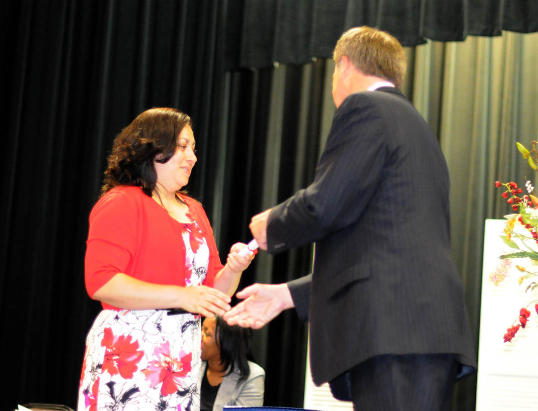 Click to enlarge,  Blanca Carcamo, of Chatham County, is congratulated by Central Carolina Community College President Bud Marchant on receiving her Pharmacy Technician certificate during the college&#8217;s May 18 Department of Continuing Education Medical Programs Graduation at the Dennis A. Wicker Civic Center. More than 100 students earned certificates in various medical programs, with some earning more than one. About 50 attended the graduation ceremony. 