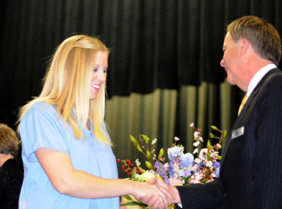 Click to enlarge,  Emily LaClair, of Moore County, is congratulated by Central Carolina Community College President Bud Marchant on receiving her Nursing Assistant I certificate during the college&#8217;s May 18 Department of Continuing Education Medical Programs Graduation at the Dennis A. Wicker Civic Center. More than 100 students earned certificates in various medical programs, with some earning more than one. About 50 attended the graduation ceremony. 