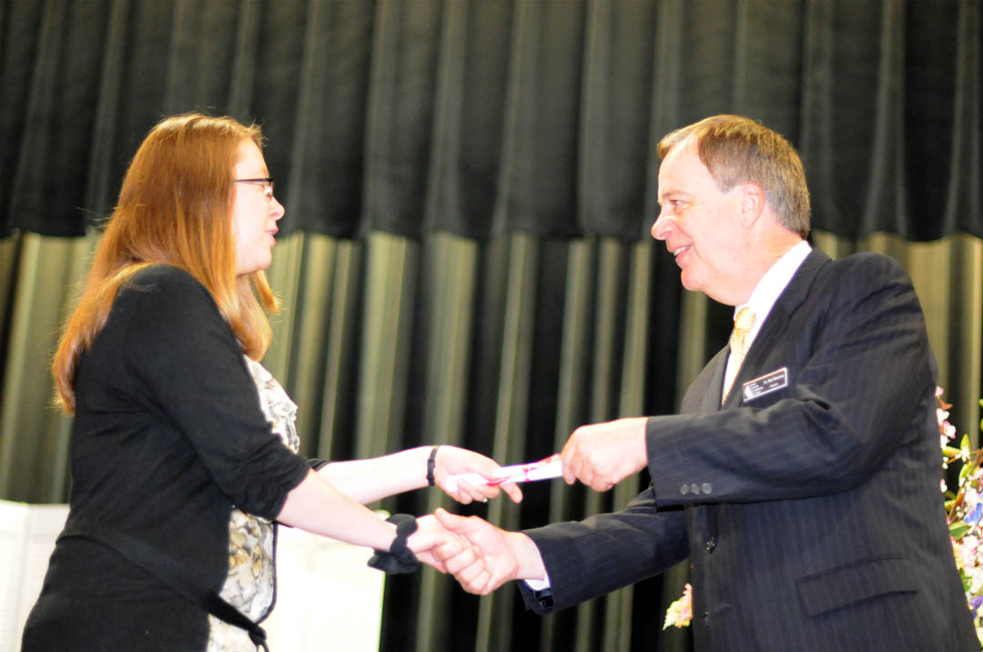 Click to enlarge,  Tabitha Norton (left), of Harnett County, is congratulated by Central Carolina Community College President Bud Marchant on receiving her Advanced EKG certificate during the college&#8217;s May 18 Department of Continuing Education Medical Programs Graduation at the Dennis A. Wicker Civic Center. More than 100 students earned certificates in various medical programs, with some earning more than one. About 50 attended the graduation ceremony. 