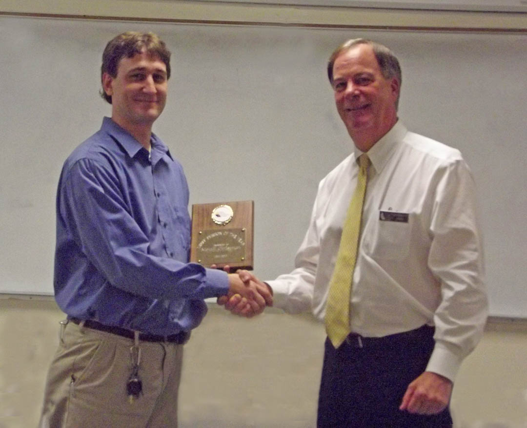 Click to enlarge,  Central Carolina Community College President Bud Marchant (right) presents MontE Christman, associate director of the college's Information Technology Department, a plaque honoring him as the college's 2011 Staff Person of the Year. Christman, of Sanford, will now compete against nominees from the North Carolina Community College System's other 57 schools to become the NCCCS 2012 Staff Person of the Year. 