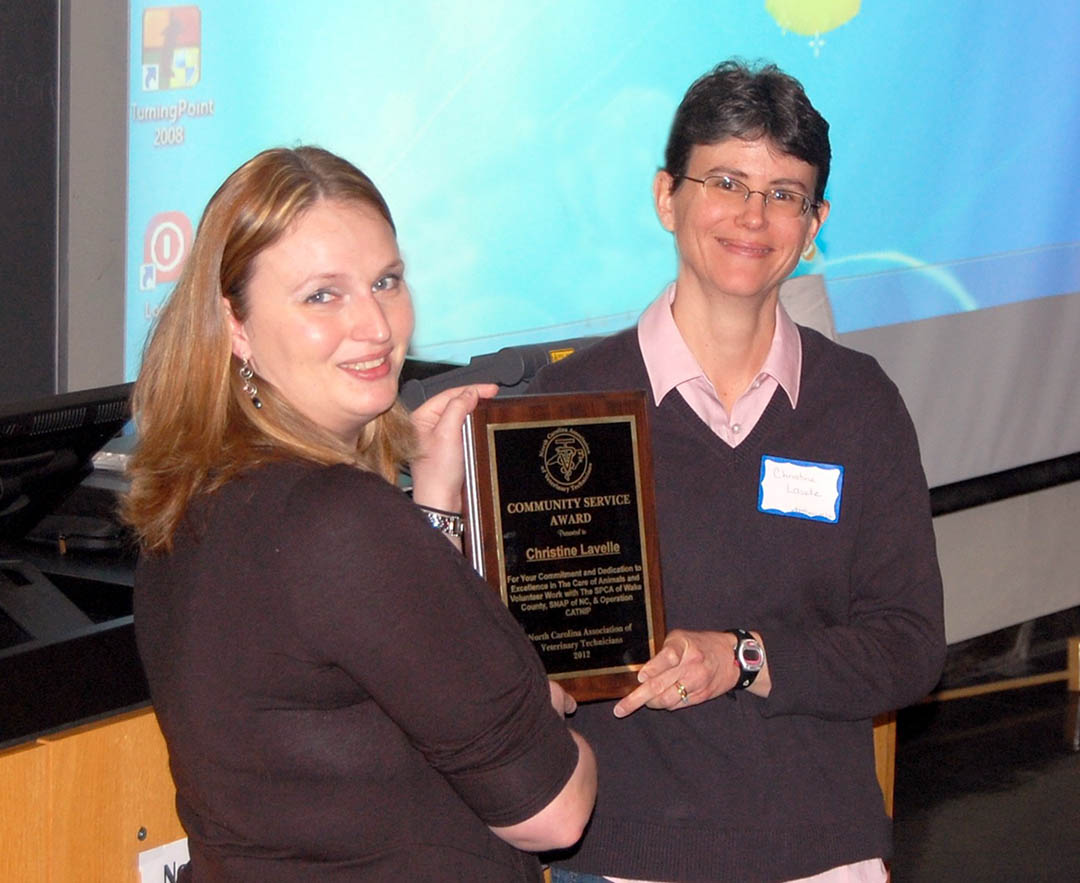 Click to enlarge,  Central Carolina Community College Veterinary Medical Technology student Christine Lavelle (right), of Cary, was honored with the N.C. Association of Veterinary Technicians' Community Service award during the association's March 10 spring conference at N.C. State University's College of Veterinary Medicine. NCAVT President Amanda Dillard (left), of Randleman, a graduate of CCCC's VMT program, presents Lavelle with the plaque honoring her for her volunteer efforts with three Wake County-based spay and neuter facilities. For more information about CCCC's five-semester Veterinary Medical Technology associate degree program, visit its Web site at: www.cccc.edu/curriculum/majors/veterinarymedical/ or call (919) 718-7234. For more information about the N.C. Association of Veterinary Technicians, visit its Web site at:  www.ncavt.org . 