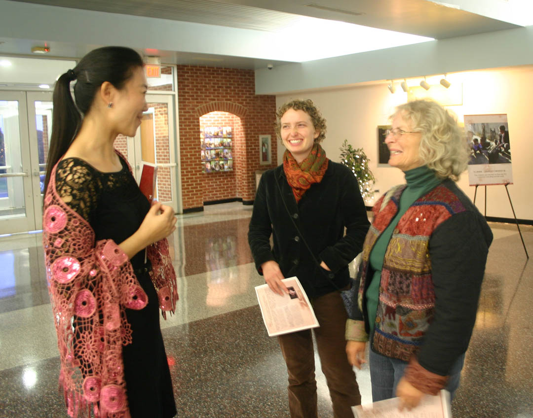 Click to enlarge,  Central Carolina Community College Confucius Classroom instructor Ling Huang speaks to visitors Maggie McRae and Laura Young, both of Lee County, during the Nov. 5 reception at the Dennis A. Wicker Civic Center for 'Traditions of China,' an exhibition of the work of Chinese photographer Yong Xiao. The exhibition runs through Nov. 26. Brochures at the exhibition explain the pictures of Chinese cultural traditions that are disappearing with globalization. For more information about Central Carolina Community College's Confucius Classroom, visit  www.cccc.edu/confucius . 