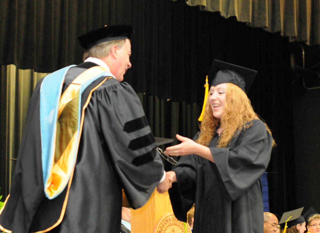 Click to enlarge,  Central Carolina Community College President Bud Marchant (left) congratulates Laura McEwen, of Chatham County, on receiving her Associate in Applied Science in Accounting during the college's Aug. 6 Summer Commencement at the Dennis A. Wicker Civic Center. The graduates earned more than 400 degrees, diplomas and certificates, with some students earning more than one. Some will continue their education at four-year institutions, while most will take their new skills and knowledge directly into the workplace. For information about programs at CCCC, visit www.cccc.edu/. 