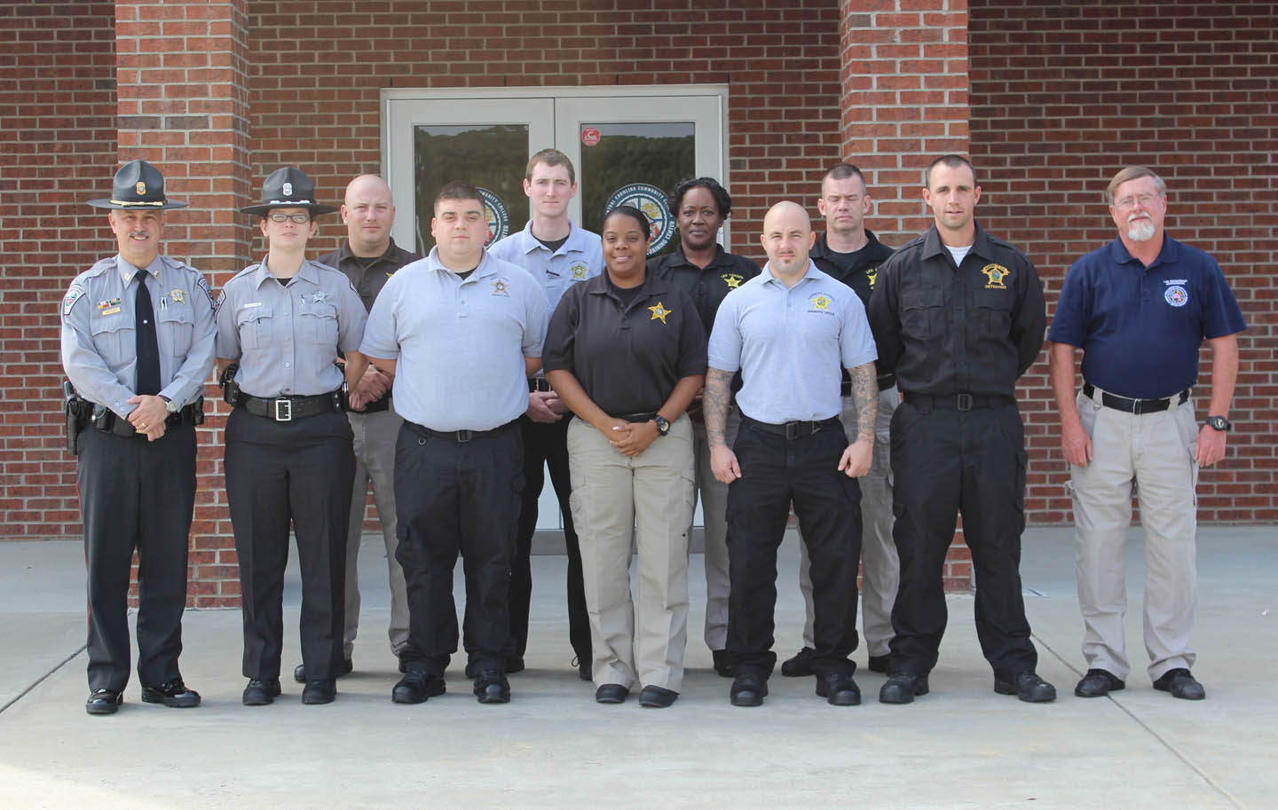 Click to enlarge,  Nine officers from the sheriff offices in Chatham, Harnett and Lee counties graduated Oct. 29 from the Detention Officer School at Central Carolina Community College's Emergency Services Training Center, in Sanford. The officers completed 168 hours of classroom and practical instruction and achieved a 90.6 grade average on the state certification examination. They are now prepared to serve as detention officers with municipal, county or regional jails in North Carolina. The course focused on four key areas: legal, physical fitness, practical applications and medical. Pictured are (first row, from left) Detention Officer School Director Capt. Doug Stuart and Detention Officer Autumn Keifer, both of the Chatham County Sheriff's Office; Detention Officer Anthony Crouch, Harnett County Sheriff's Office; Detention Officer Toshiba Battle, Lee County Sheriff's Office; Detention Officers Peter Cipriano and Robert Norris, both of the Harnett County Sheriff's Office; and School Director Larry Foster, CCCC coordinator for Law Enforcement Training; and (back row, from left) Detention Officer Michael Fay, Lee County Sheriff's Office; Detention Officer Johnathan Edwards, Harnett County Sheriff's Office; and Detention Officers Annette Blue and Les Goodwin, both of the Lee County Sheriff's Office. For more information about the Detention Officer School, contact Larry Foster at 919-777-7772 or lfoster@cccc.edu.  