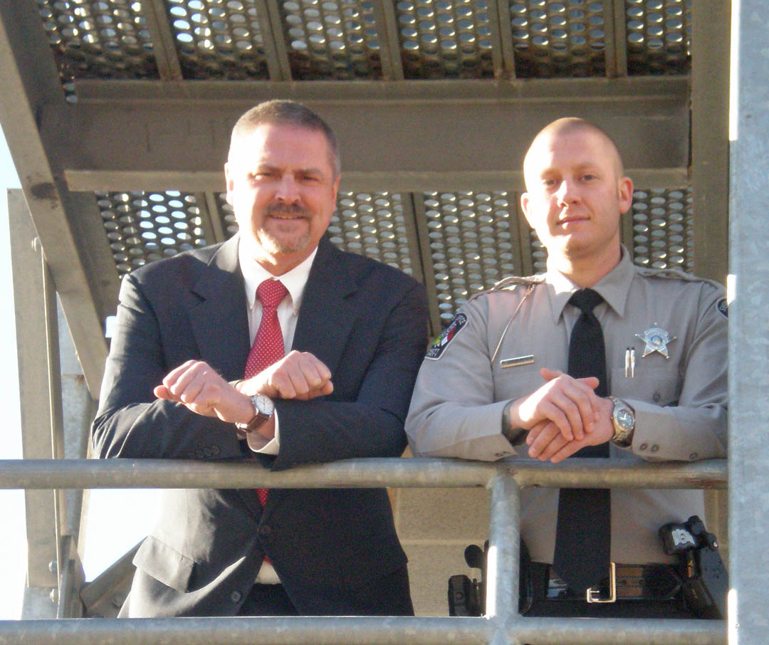 Click to enlarge,  Dr. Robert Powell (left), chair of Central Carolina Community College's Justice Studies Department and director of its Basic Law Enforcement Training program, and Harnett County Sheriff's Department Deputy Michael Klingman, stand on the rescue tower at the college's Emergency Services Training Center, in Sanford. Klingman is a graduate of the BLET program and credits his training for the skills he and other graduates bring to their duties. For more information about the BLET program at CCCC, visit www.cccc.edu or contact Robert Powell at 919-777-7774 or by e-mail at rpowe254@cccc.edu.  