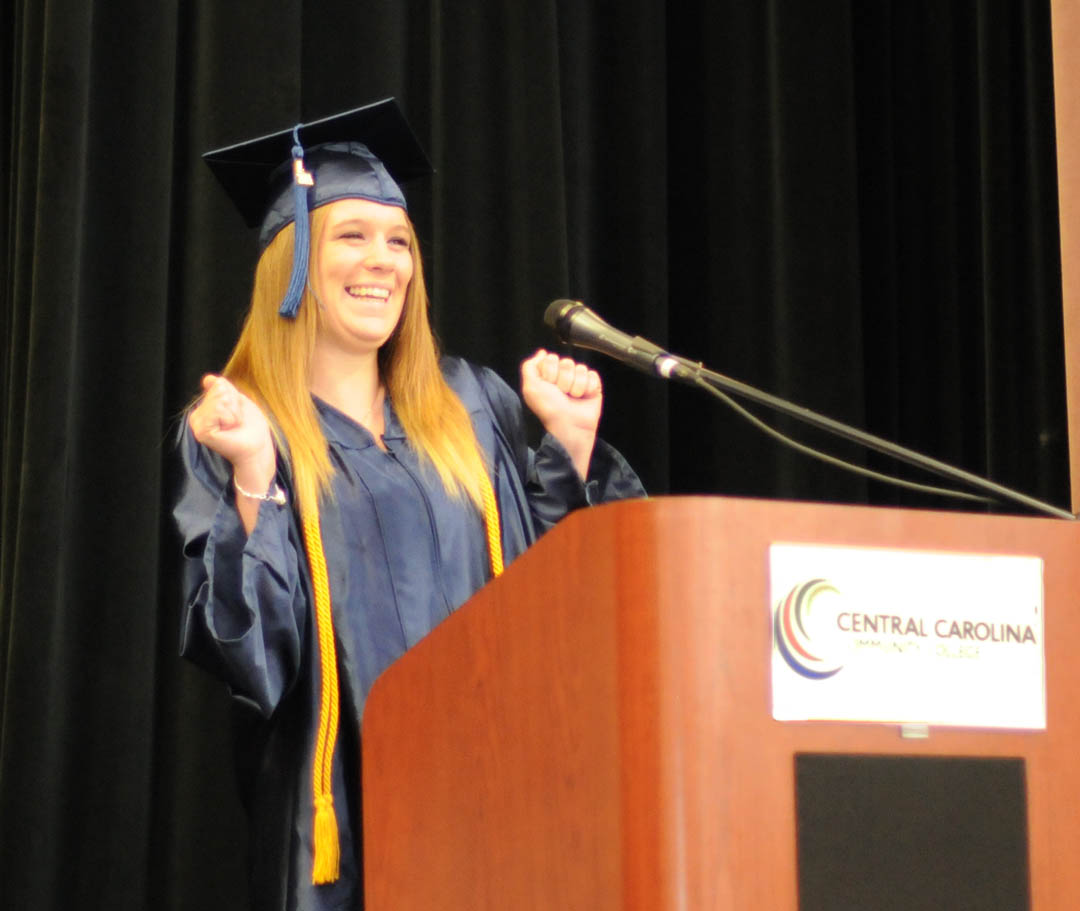 Click to enlarge,  Graduating student Virginia Osborne, of Harnett County, shows her excitement as she congratulates her fellow Central Carolina Community College Adult High School/GED program graduates at the commencement ceremony June 19 in the Dennis A. Wicker Civic Center. Osborne plans to attend CCCC, then transfer to a university to study to become a meteorologist. Seventy students completed their studies for a diploma during the spring semester. Most plan to continue their education at the college. The Adult High School and GED programs are under the college's College and Career Readiness Department. For more information, visit www.cccc.edu or call a CCR office: Chatham County - 919-545-8661 at the Siler City Center or 919-545-8028 at the campus in Pittsboro; Harnett County - 910-814-8974; or Lee County - 919-777-7707 at the Lifelong Learning Center at W.B. Wicker Business Campus. Para mas informacion en espanol - 919-545-8667 or jherbon@cccc.edu. 