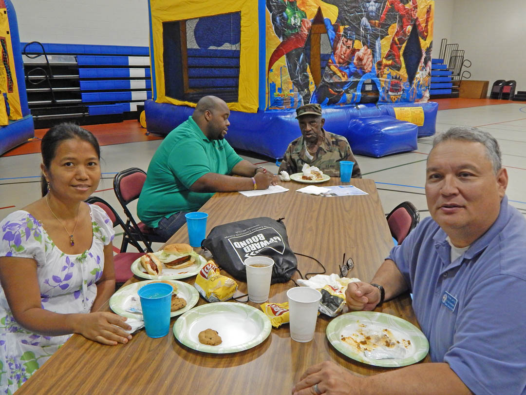 Click to enlarge,  Michael Lanning (right), retired Air Force Gulf War veteran, now serves as the Junior Vice Commander/Chapter Service Office for the Disabled American Veterans Chapter 74, in Erwin. He and his wife, Imelda Lanning (left), took part in Central Carolina Community College's July 10 Veterans Upward Bound Appreciation Day. Also at the event was Vietnam War veteran James Douglas (back, right), of Sanford, speaking with VUB Academic Advisor Wilson Lester (back left). The Appreciation Day was a family-friendly event for veterans either enrolled in or interested in learning about the services provided by VUB. For more information about Central Carolina Community College's Veterans Upward Bound program, call 919-718-7463 or email veteransub@cccc.edu. Information is also available at www.cccc.edu/vub/. 