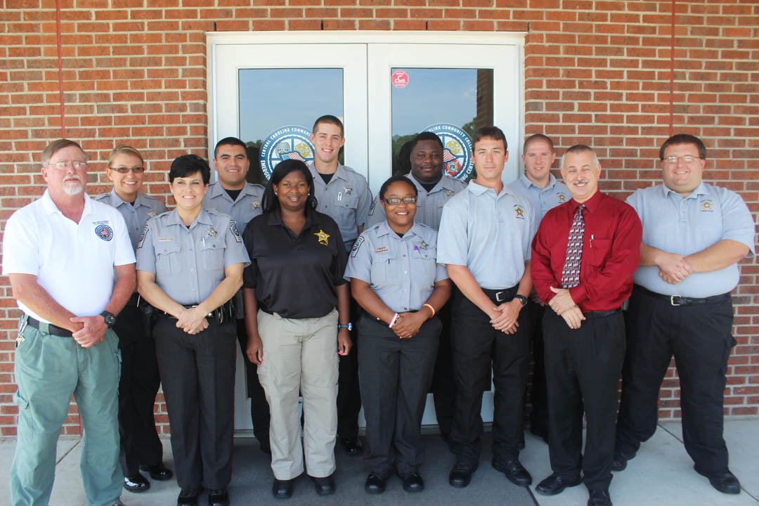 Click to enlarge,  Ten law enforcement officers from the Chatham County Sheriff's Office, Harnett County Sheriff's Office and Lee County Sheriff's Office have completed training for and passed a state examination to receive their certification as Detention Officers. The officers graduated Sept. 3 from the Detention Officer School at Central Carolina Community College's  Emergency Services Training Center, in Sanford. The 172-hour Detention Officer course, mandated by the North Carolina Sheriff's Education and Training Standards Commission, is comprised of 22 instructional blocks. It includes topics such as Legal Aspects, Contraband Searches, Medical Care, Fire Emergencies, Suicide, and Aspects of Mental Illness. The students achieved a 91.4 percent class average on the final state certification exam. Pictured (front from left) are Larry Foster, CCCC Law Enforcement coordinator; Deputy Spring McNulty, CCSO; Detention Officer Diaundra Baldwin, LCSO; Detention Officer Taelor Tyson, CCSO; Detention Officer Michael Pittman, HCSO; Capt. Doug Stuart, CCSO/school director; and Detention Officer Jerry Bohman, HCSO; and (back, from left) Deputy Ashley Little, Deputy Feliciano Jiminez, Deputy Jed Bristow, and Detention Officer Clifton Brooks, all of the CCSO; and Detention Officer Jimmy Holbrook, HCSO. For more information about the college's Detention Officer School, contact Larry Foster,  919-777-7772, or email lfoster@cccc.edu. 
