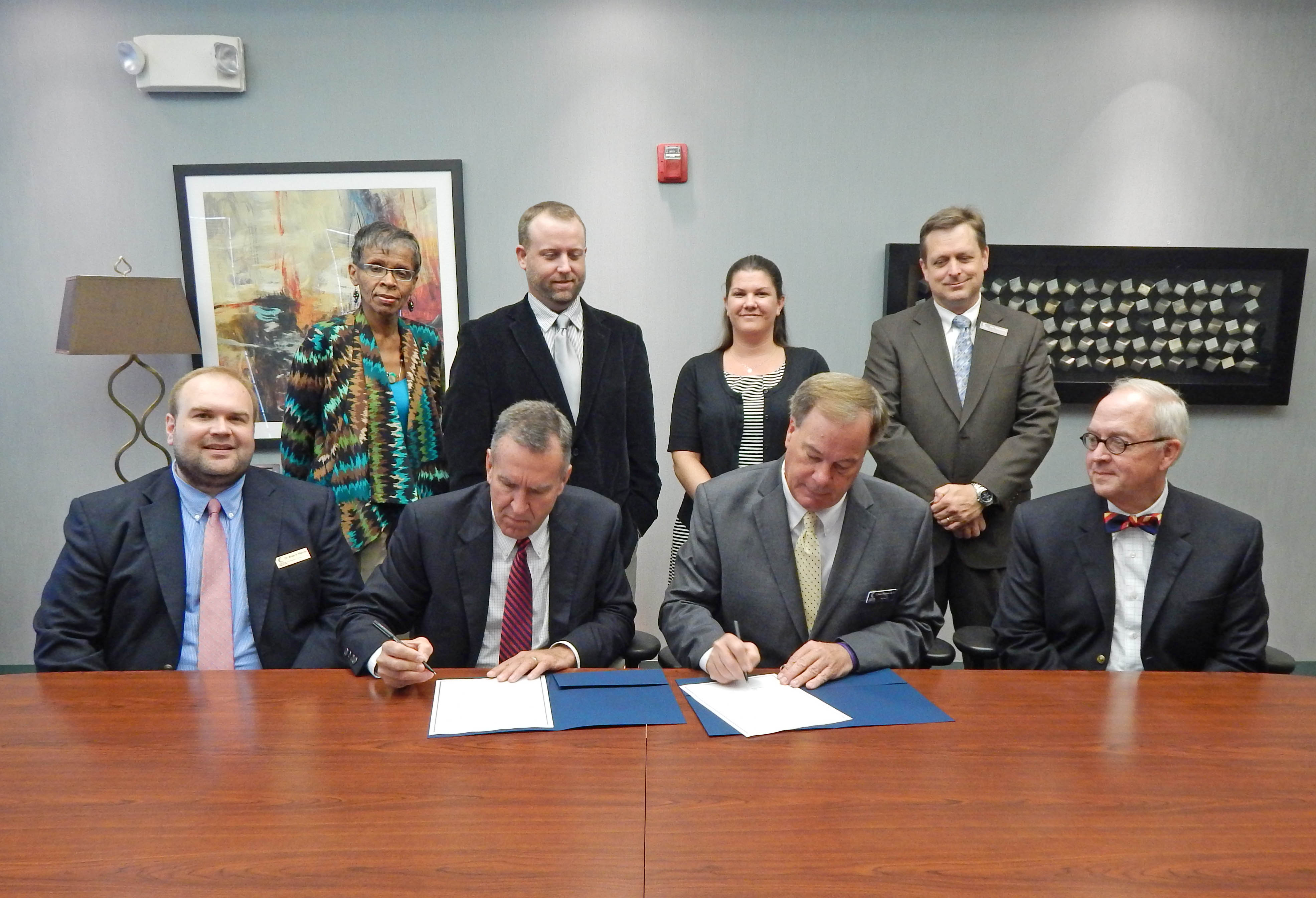 Click to enlarge,  Dr. Dewey Clark (center left), president of North Carolina Wesleyan College, and Dr. Bud Marchant, president of Central Carolina Community College, sign a Memorandum of Understanding between the two institutions that will expand their partnership. The signing took place Sept. 9 at CCCC's Lee County Campus. N.C. Wesleyan will start offering some bachelor's degree classes at the Lee Campus in May 2015, as well as having an admissions officer/advisor at the campus. Pictured with the presidents are Dr. Brian Merritt (seated left), CCCC vice president of Student Learning; Dr. Michael Brown (seated right), NCWC provost; and (back, from left) Sandra Carmichael, NCWC Durham Campus director; Dr. Evan Duff, NCWC vice president of Adult and Professional Studies; Katie Farrell, NCWC executive director of Community College Partnerships; and Jon Matthews, CCCC associate provost/dean of Business &amp; Media Technologies, Education and University Transfer. For more information about CCCC programs, go to www.cccc.edu. For more information about N.C. Wesleyan, visit www.ncwc.edu. 