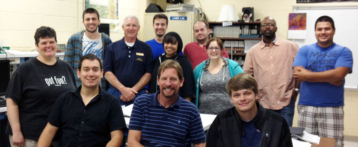 Click to enlarge,  Students in Central Carolina Community College's Laser Photonics Technology program look forward to a bright future. Pictured are, from left: front row, Shelley Parker, Al DeLong, Chris Baggett and Colt Dudley; second row, Chris Loehr, Instructor Gary Beasley, Alex Voytik, Andreina "Brill" McGiver, Jeremy Knoll, Kaitlyn Camp, Danny Robinson and Carlos Salas Moreno. 