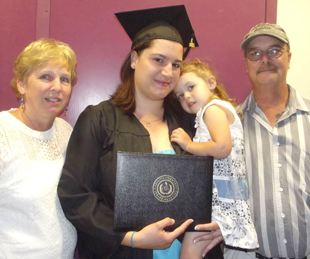 Click to enlarge,  Ashley Reed, of Chatham County, visits with family after receiving her Diploma in Medical Assisting at the Central Carolina Community College commencement exercises on May 22 at the Dennis A. Wicker Civic Center. 