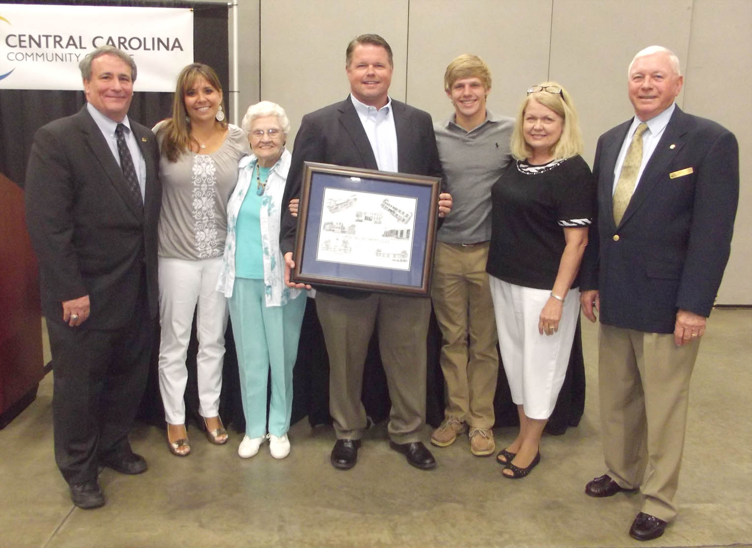 Click to enlarge,  Jamie Kelly (center) is joined by family and friends as he was saluted for his service to the Central Carolina Community College Board of Trustees.   Kelly_DSCF6603_7-22-15_1b.jpg 