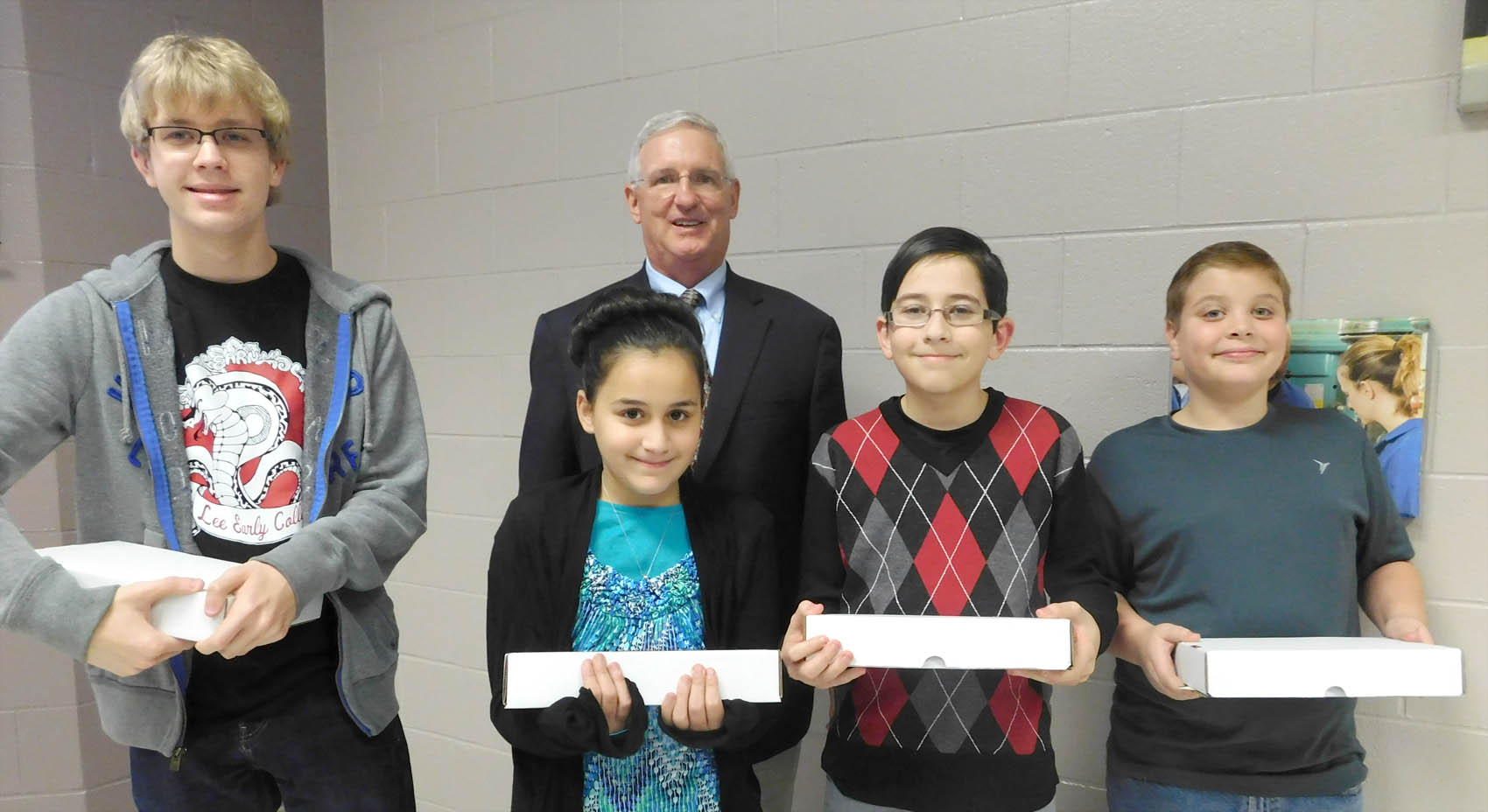 Click to enlarge,  An essay contest for students was part of the Central Carolina Community College International Year Of Light celebration. Gary Beasley, CCCC Laser and Photonics Technology Lead Instructor, stands behind winners Seth Kuenzler, Samia Mohamed, Tarrek Mohamed, and Avery Chumley. 