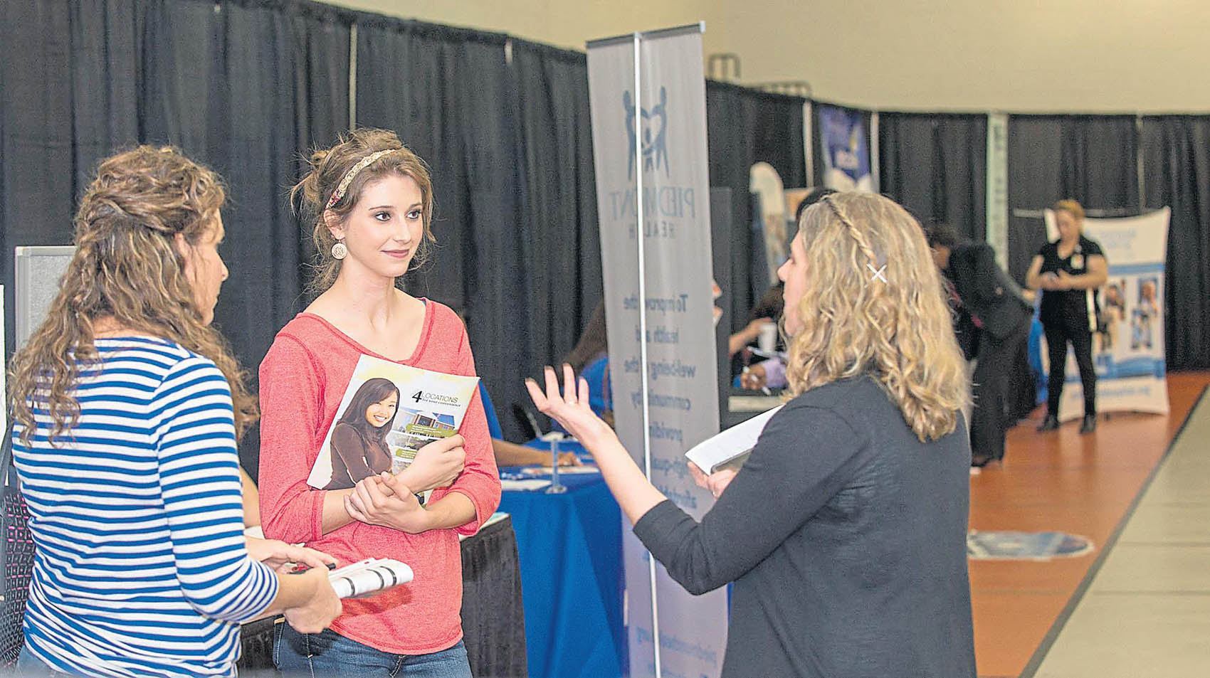 Click to enlarge,  Hannah Hunsinger | The Sanford Herald   Sylvia Wrenn, 17, (second from left) and her mom Allison Wrenn, of Fuquay-Varina, chat with Lisa Godfrey, Dean of Health Sciences at CCCC, about nursing school options during the Healthcare Career Fair at CCCC on May 3. 