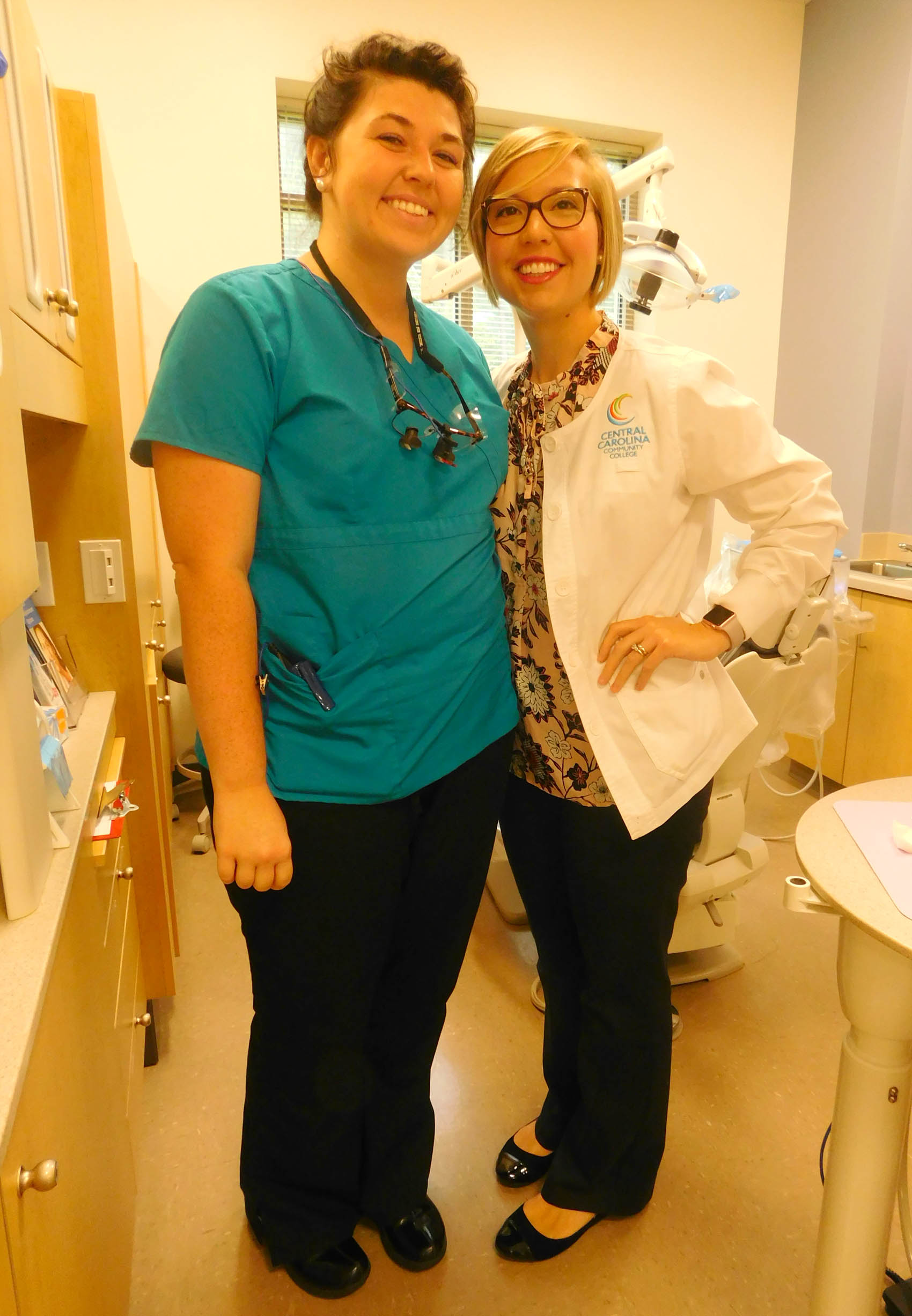 Click to enlarge,  Central Carolina Community College Dental Hygiene student Briana Willett, from Bear Creek, is preparing for work at the East Carolina University School of Dental Medicine's Community Service Learning Center in Lillington. She is pictured with Danielle Bruner, CCCC Dental Hygiene Clinical Coordinator/Instructor. The CCCC Dental Programs have begun a new partnership with the ECU School of Dental Medicine's Community Service Learning Center in Lillington. 