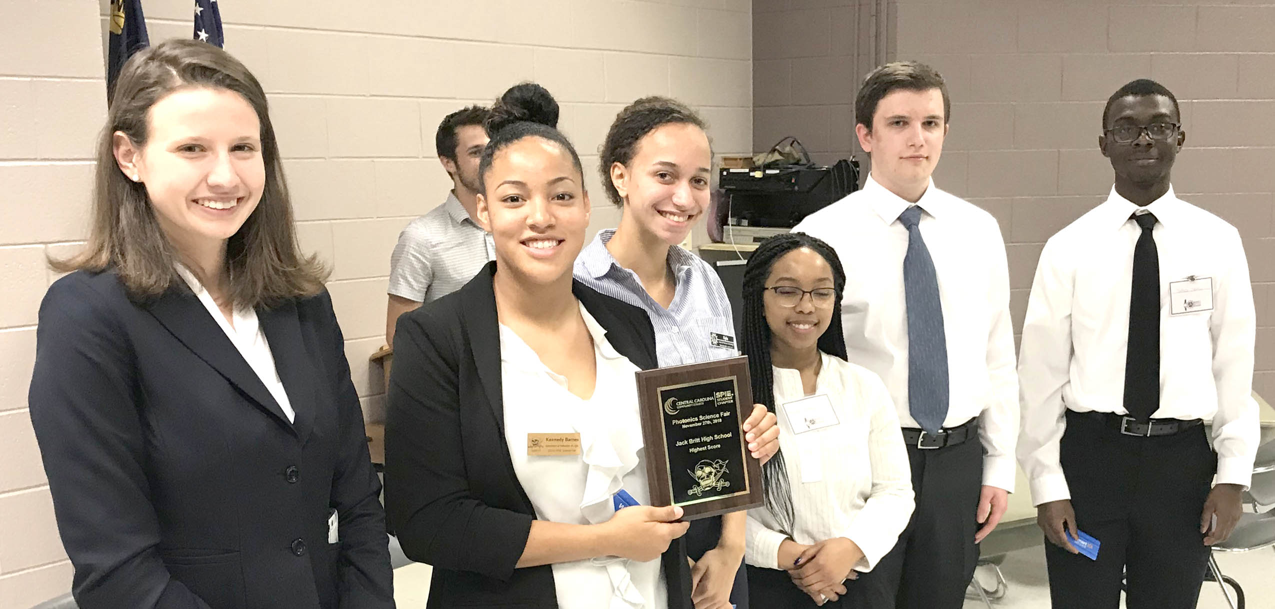 Click to enlarge,  Isabelle Karis (left), second-year CCCC laser student and Laser Club president, presents an award to members of the Jack Britt High School team. 