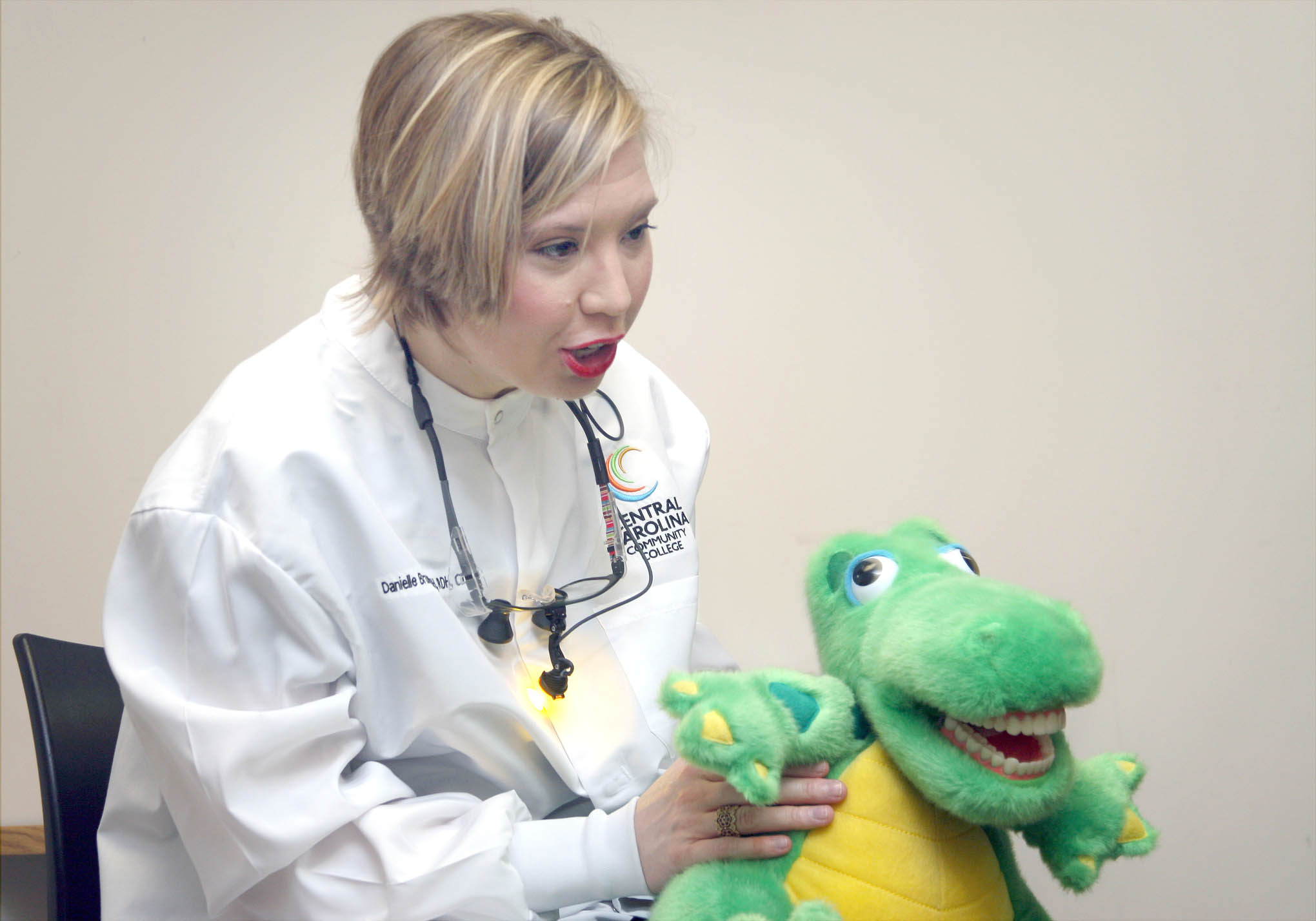 Click to enlarge,  CCCC Dental Hygiene Clinical Coordinator/Instructor Danielle Bruner entertained children using a stuffed alligator with a perfect set of human teeth during last year's Give Kids A Smile event. The annual Give Kids A Smile program is returning to the Central Carolina Dental Center, 1815 Nash St., Sanford. Free dental services will be available for children from 8 a.m. to 3 p.m. on Friday, Feb. 15.  