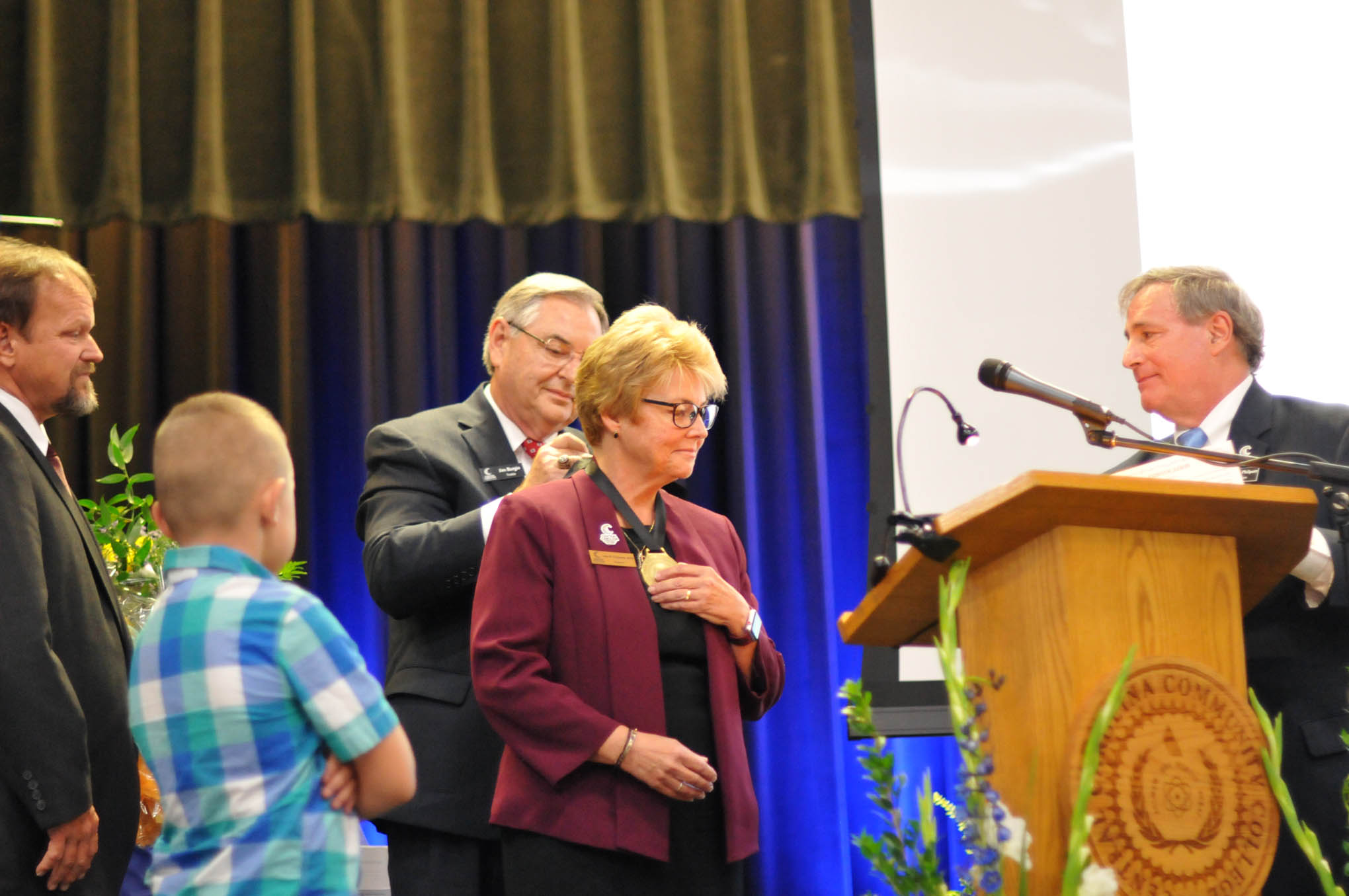 Click to enlarge,  Central Carolina Community College President Dr. Lisa M. Chapman receives the Presidential Medallion from Jim Burgin, Vice Chairman of the CCCC Board of Trustees, and from Julian Philpott (right), Chairman of the CCCC Board of Trustees, during her Installation as CCCC President on Sept. 26. 