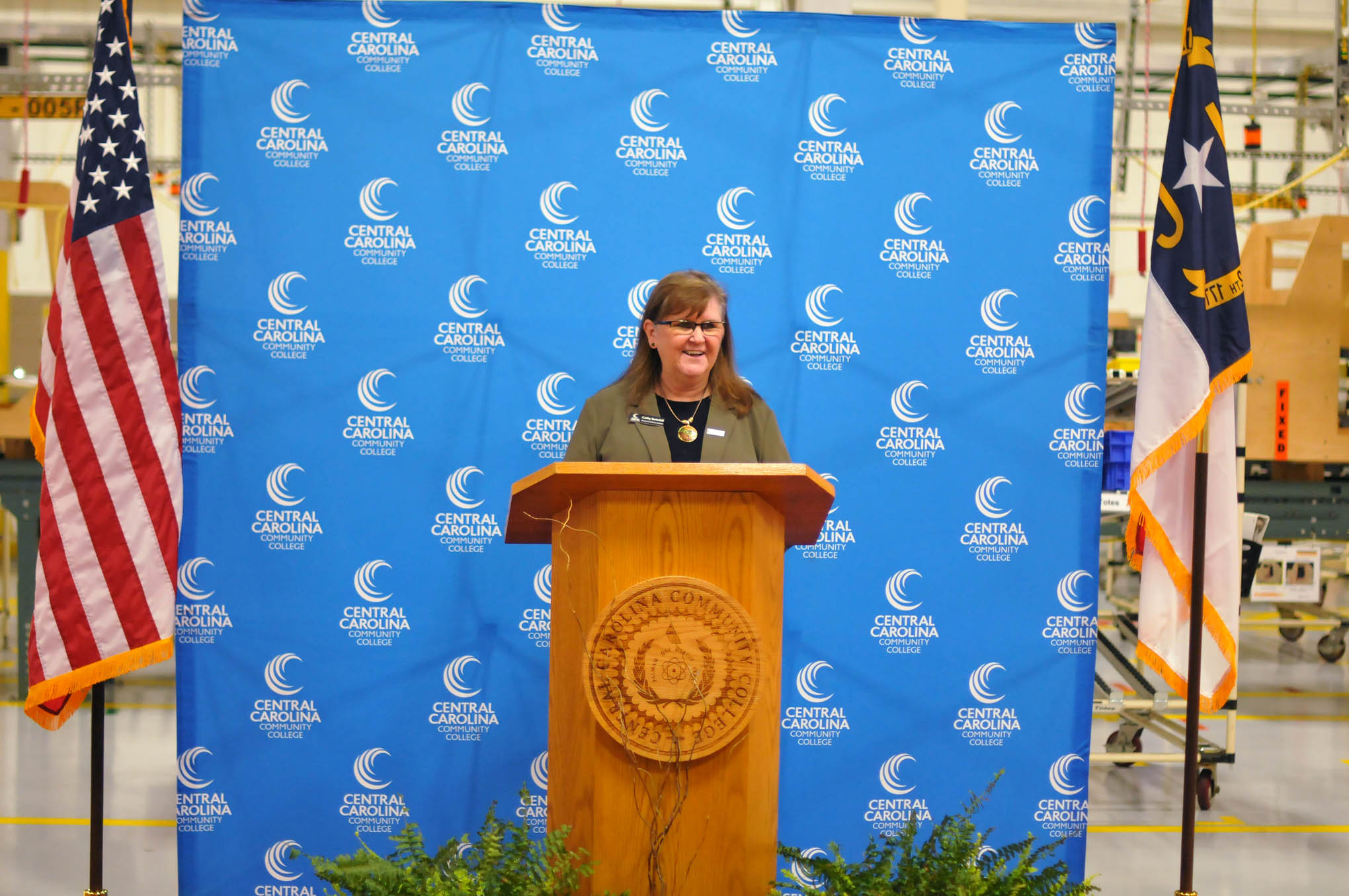 Click to enlarge,  Central Carolina Community College Director of Industry Services Cathy Swindell speaks at the 10,000 hours of industrial training celebration event. 