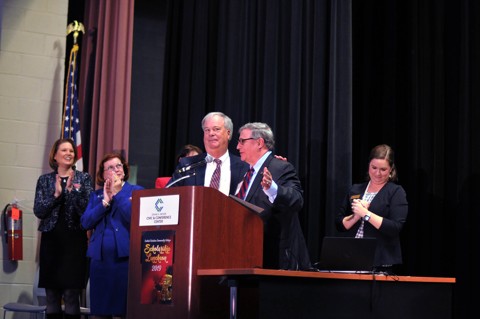 Click to enlarge,  Dr. T. Eston "Bud" Marchant (podium left) shares the moment with Central Carolina Community College Trustees' Chairman Julian Philpott as Mr. Philpott announced the naming of Marchant Hall on the CCCC Lee Main Campus in Sanford, N.C. 