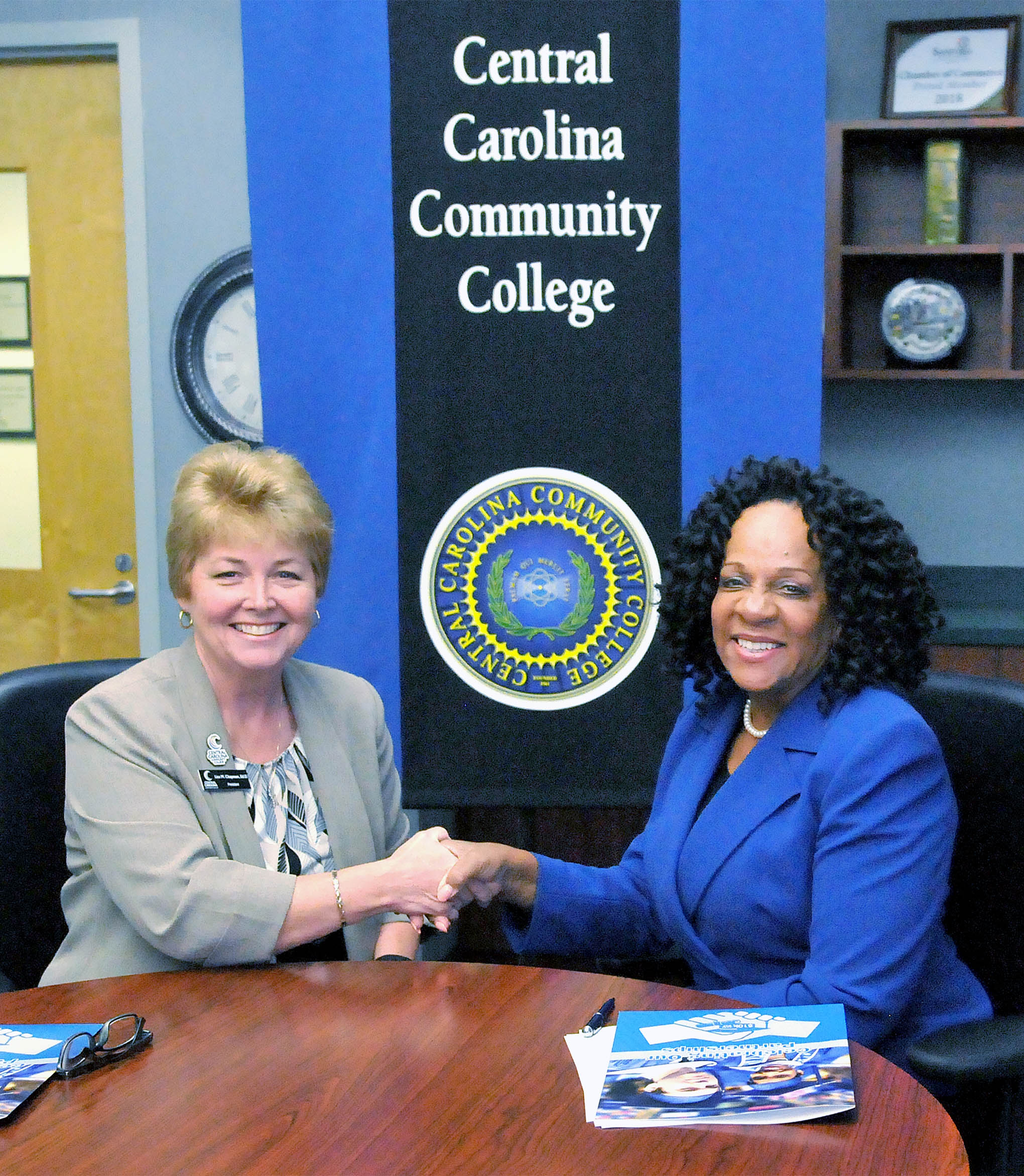 Click to enlarge,  Central Carolina Community College President Dr. Lisa M. Chapman (left) and Fayetteville State University Interim Chancellor Dr. Peggy Valentine (right) sign an agreement that permits CCCC Associate Degree graduates to complete an online Bachelor's Degree at FSU at a total cost of no more than $10,000 in out-of-pocket expenses, or approximately $5,000 at CCCC and $5,000 at FSU. Students eligible for federal and state grants will likely pay less than $10,000 out of pocket. 