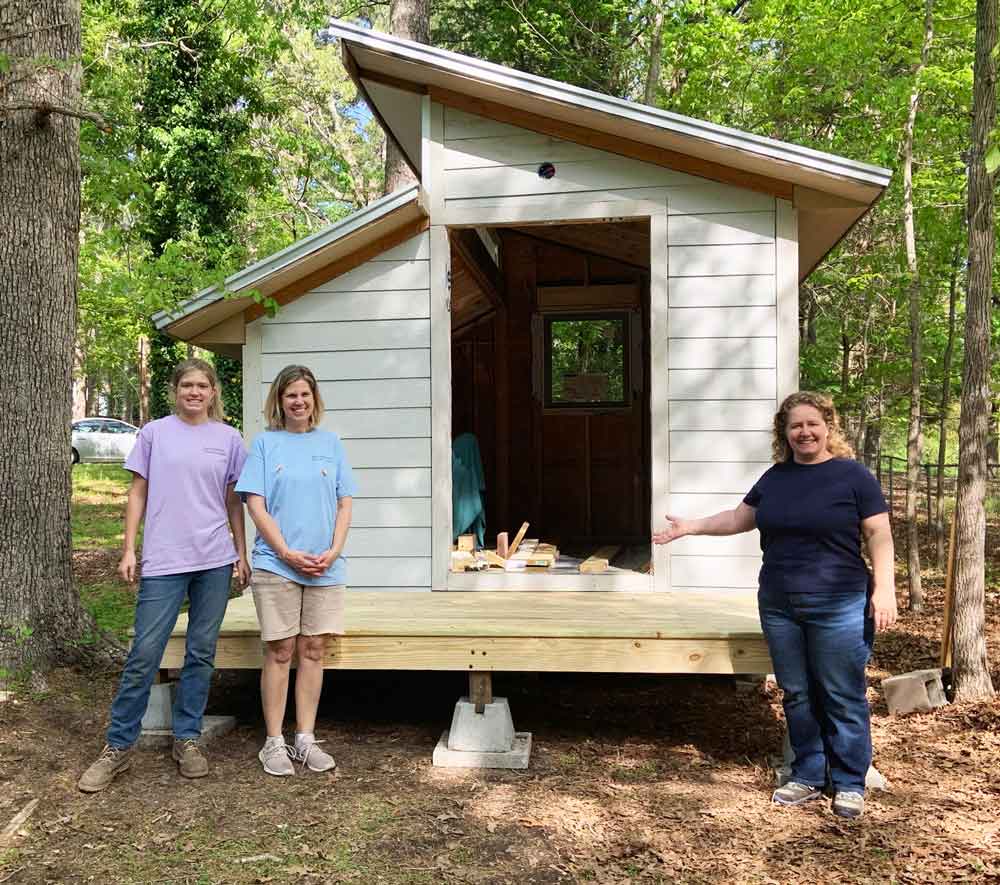Click to enlarge,  Grace Whittington (left), Cindy - Grace's mother (center), and Millie Brobston (right) look over the deck built by Grace for Millie's new shed. Grace and Millie met through the Women in Construction class at Central Carolina Community College. 