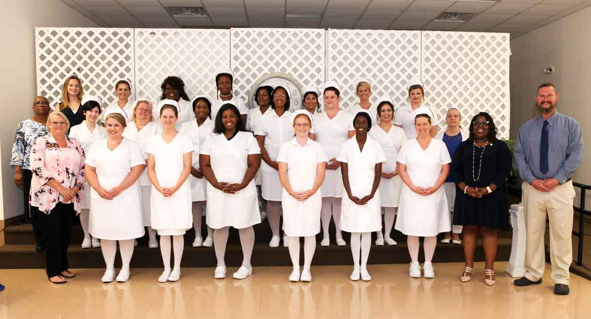 Click to enlarge,  Members of the Central Carolina Community College Louise L. Tuller School of Nursing Practical Nursing Class of 2021 are pictured with faculty and staff members, left to right: top row, Christy Jones (Admin. Asst.), Emily Johns, Tierra Hudson, Gwendolyn Horne, Carol Dejonge, Vanessa Castro, Martha Cameron, and Ashley Baker; middle row, Juanita Carter (Faculty), Paulina Rogers, Amanda Norris, Tracy McNeill, Apollonia McLean, Christen Lynch, Angelina Longoria, and Terry Cebulski-Field (Faculty); front row, Dr. Barbara Campbell (Department Chair), Samantha Toler, Stephany Tilley, Lashonda Thomas, Jensine Taylor, Alyssia Staton, Linda Ross, Dr. Consuela Blaizes (CCCC Practical Nursing Program Director), and Christopher Bailey (Faculty); not pictured, Gregory Koher. 