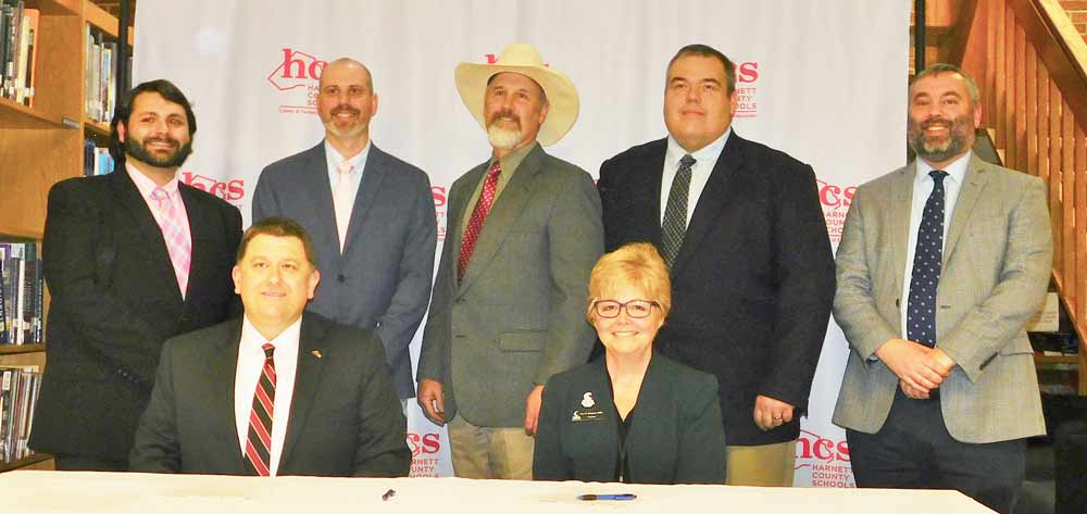 Click to enlarge,  Harnett County Schools Superintendent Dr. Aaron L. Fleming and Central Carolina Community College President Dr. Lisa M. Chapman (right) celebrate the signing of an agreement for the formation of the Harnett Agriculture Academy. Also joining the celebration are, left to right: Agriculture teachers Jacob Fipps, John Hardee, Gary Pierce, and Andy Cole, and Triton High School Principal Ryan McNeill. 